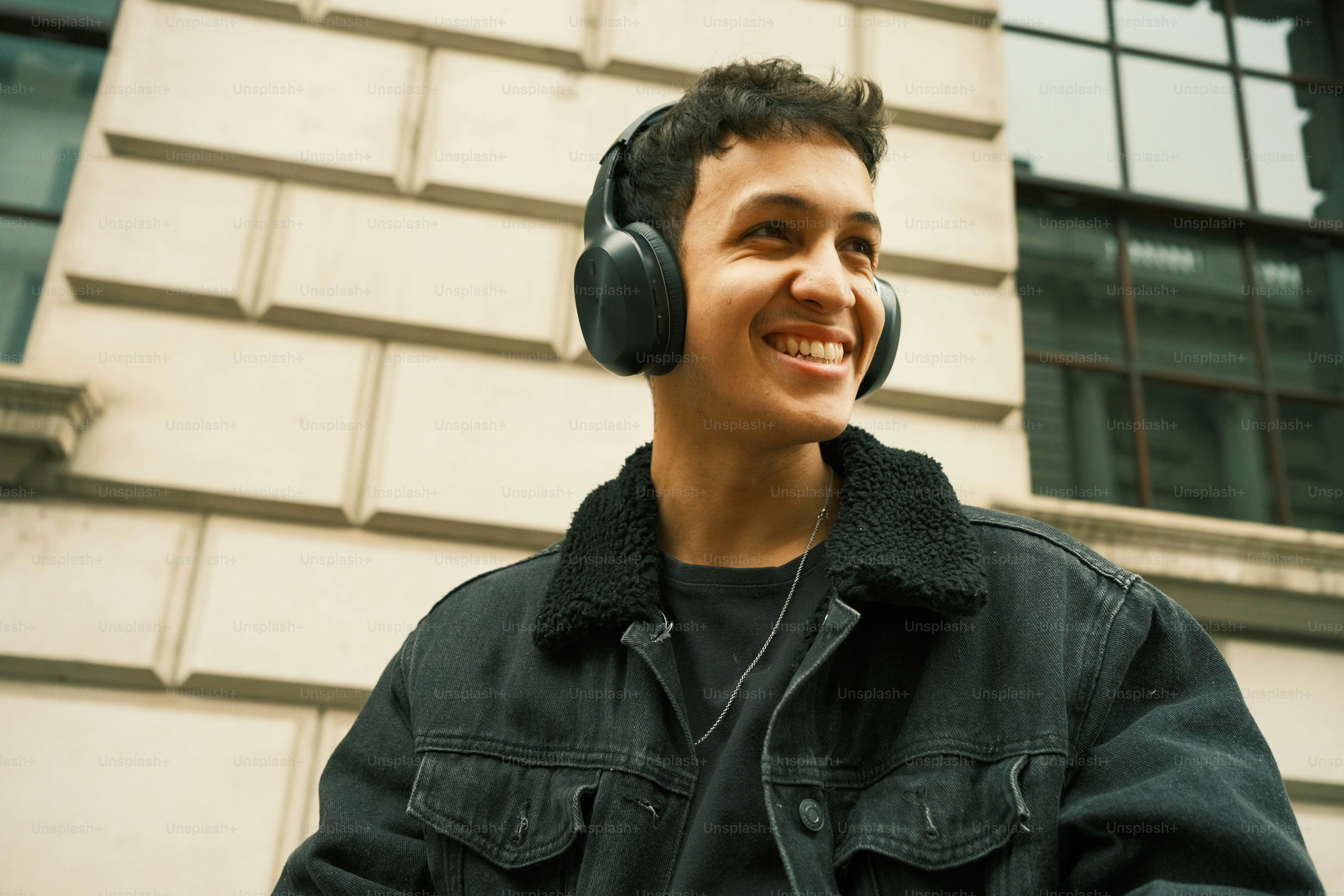 Un hombre con auriculares parado frente a un edificio
