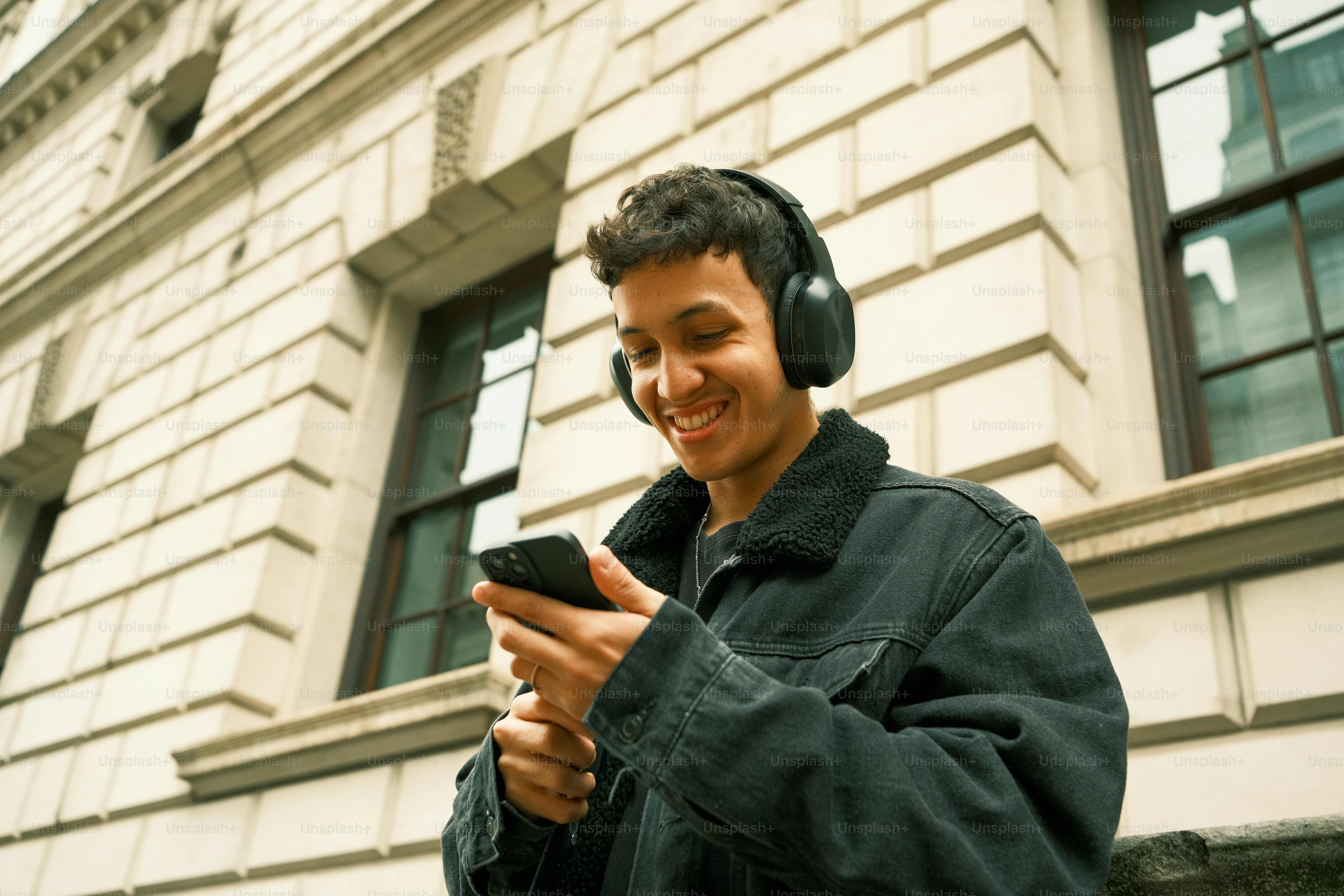 헤드폰을 낀 남자가 휴대폰을 보고 있다