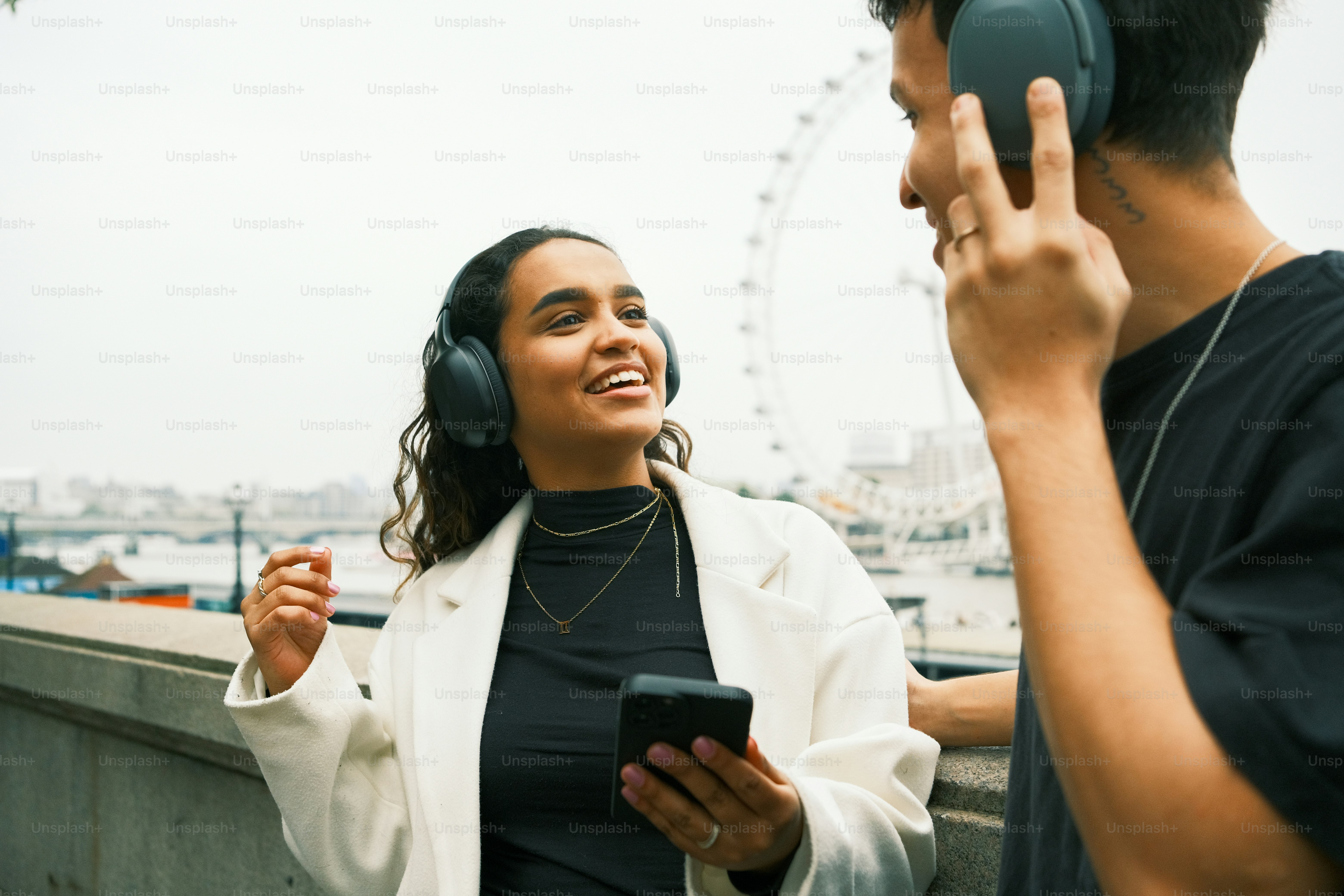 헤드폰을 낀 여성 옆에 서 있는 남성