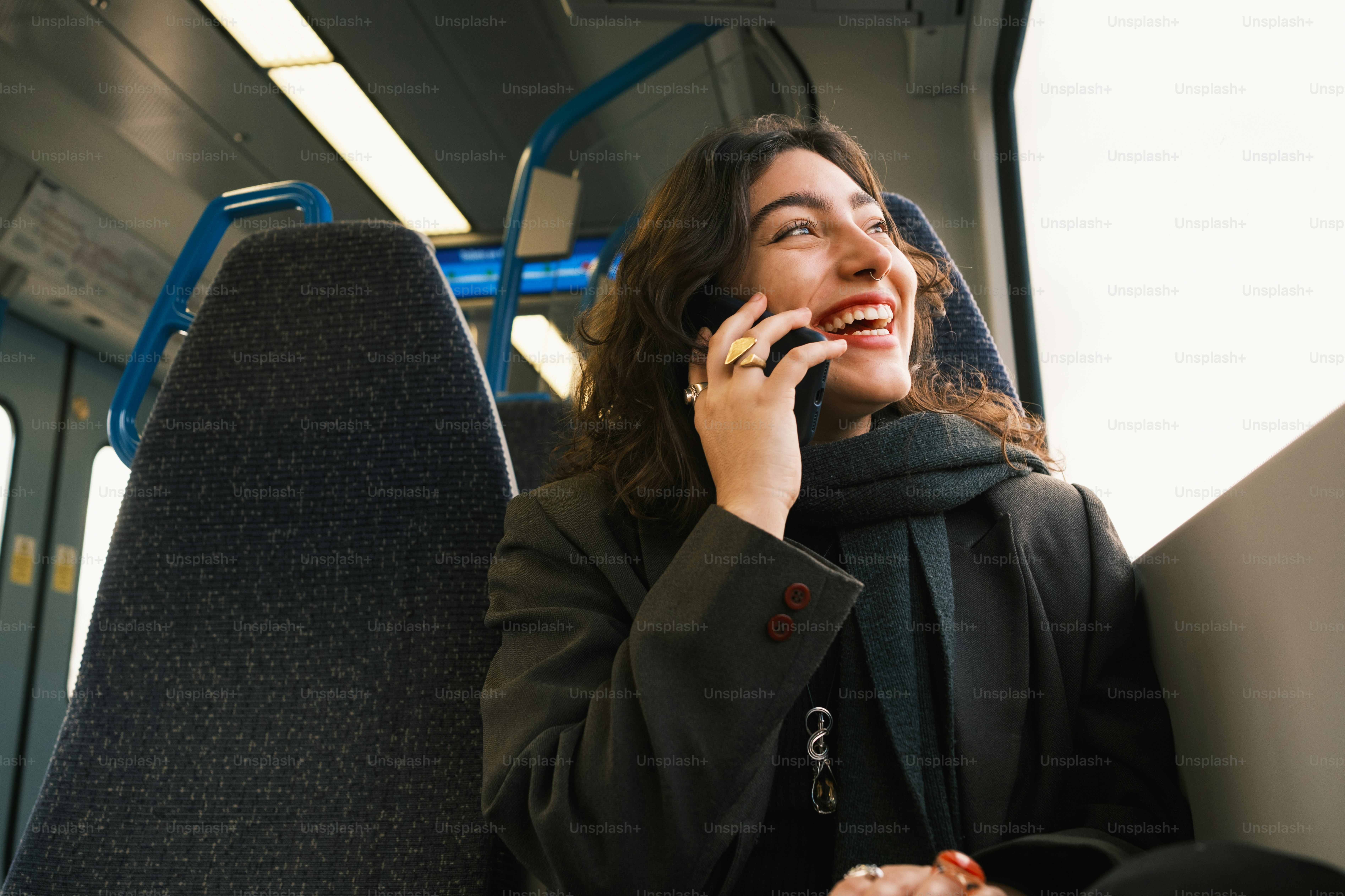 A woman talking on a cell phone while riding a bus
