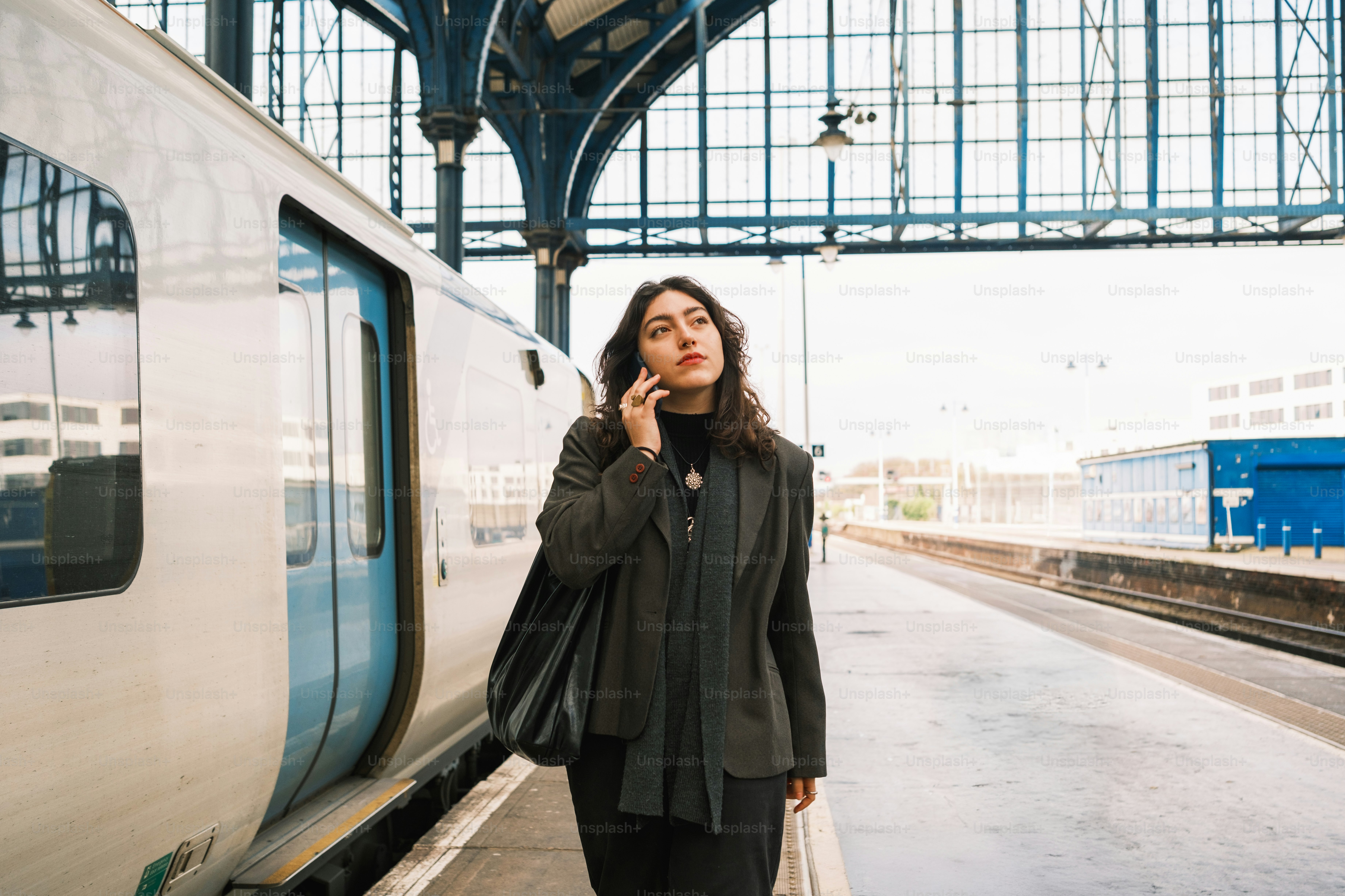 A woman standing next to a train at a train station