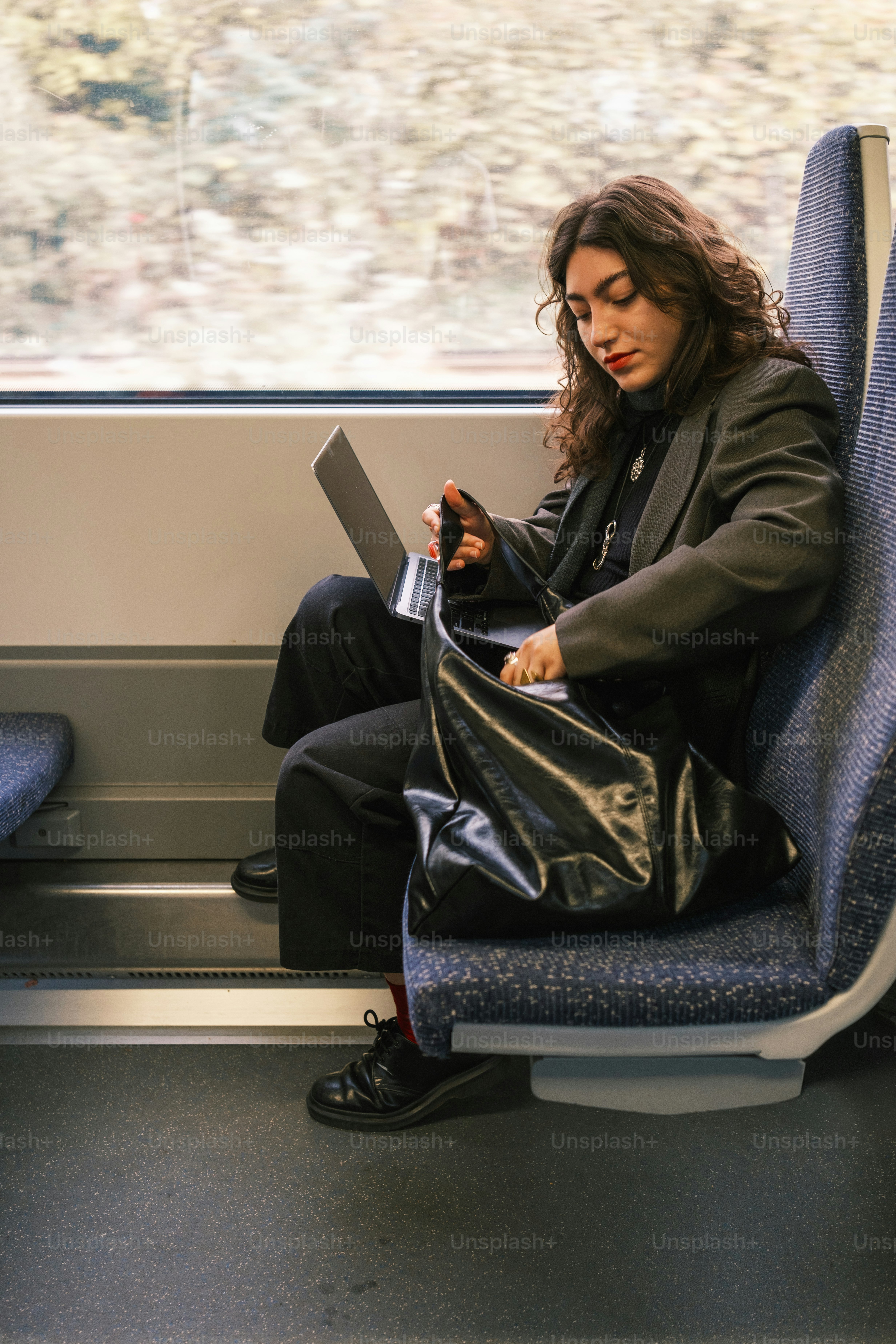 A woman sitting on a train holding a purse