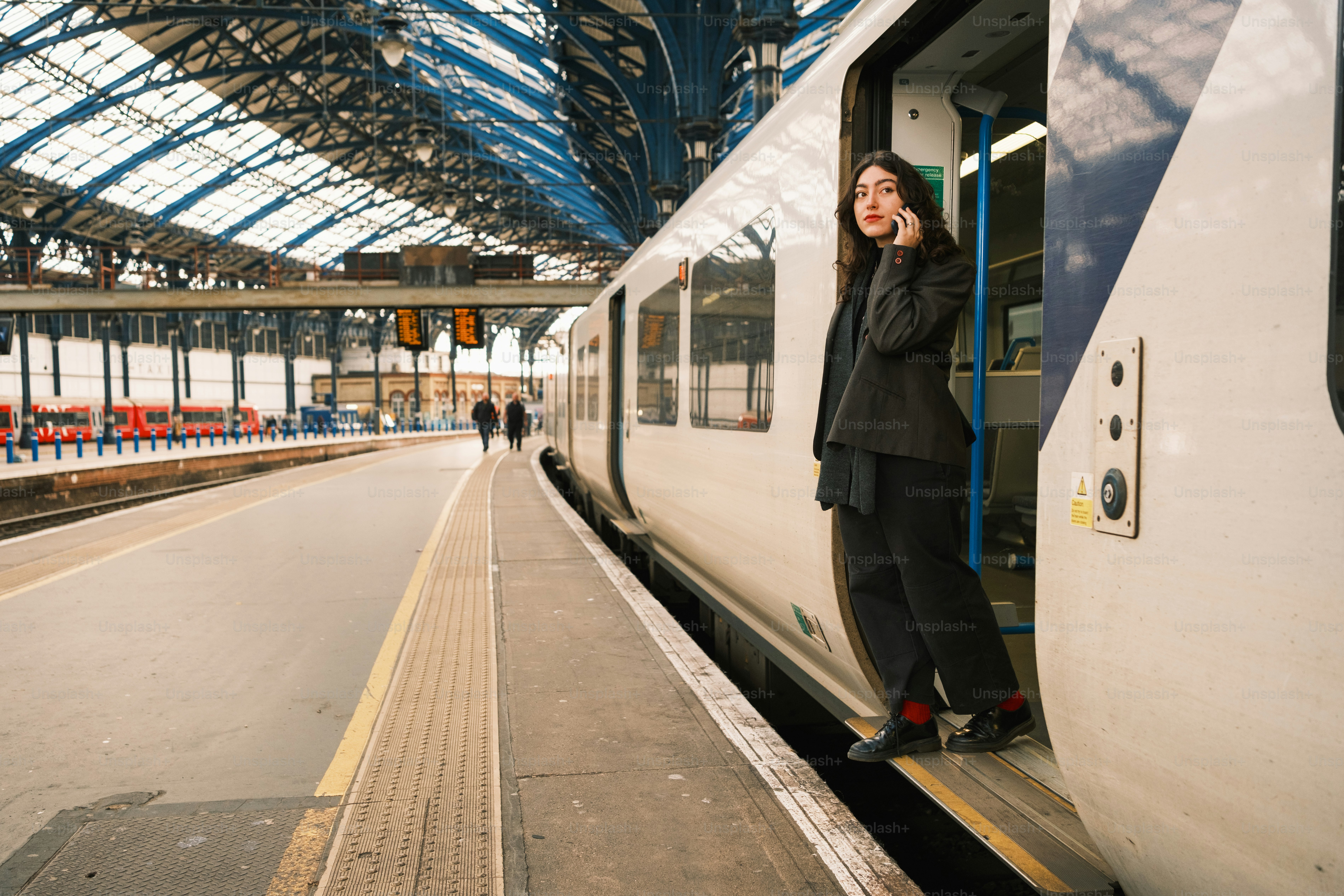 A woman standing on the side of a train at a train station