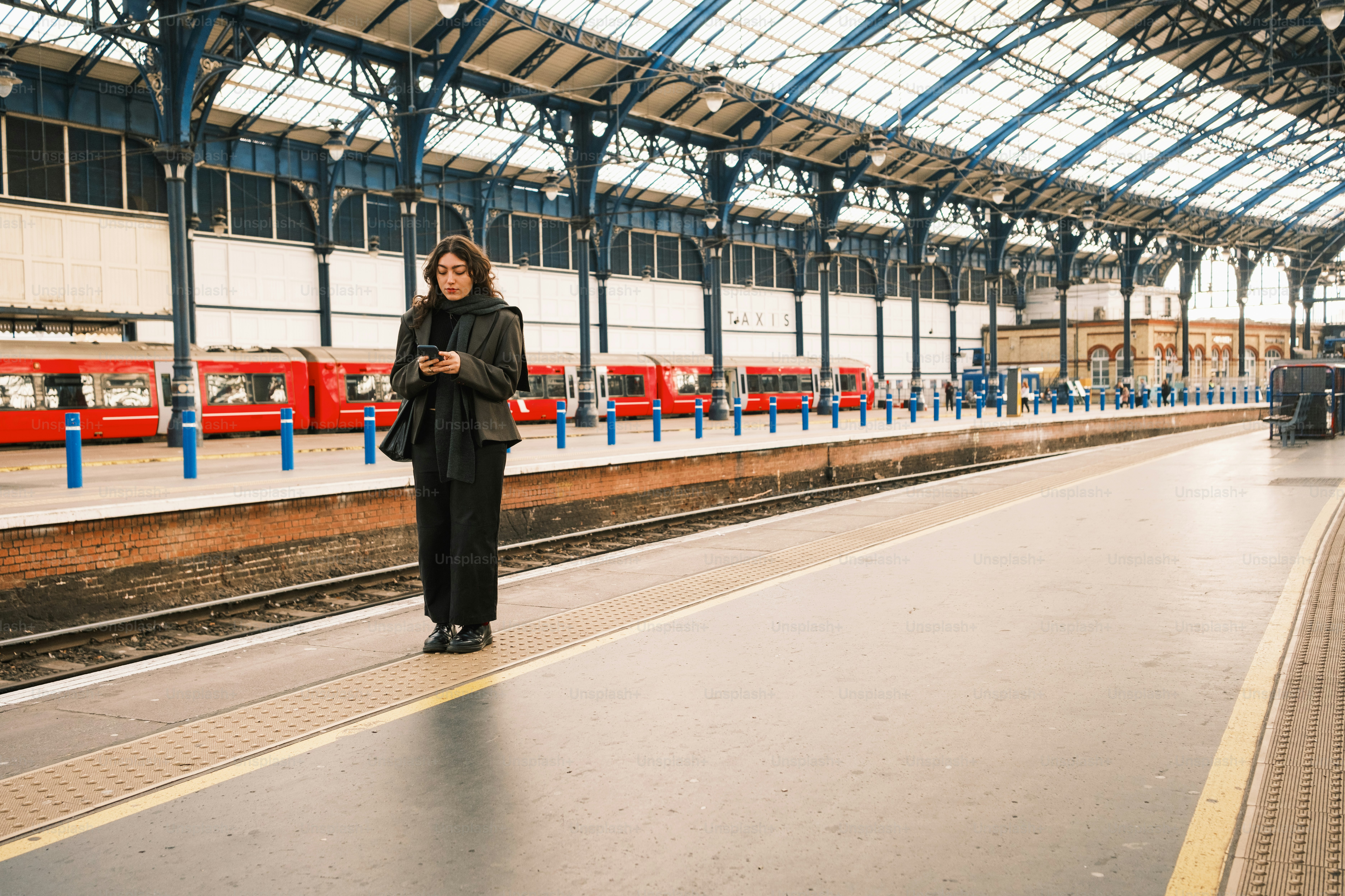 A woman standing in a train station next to a train