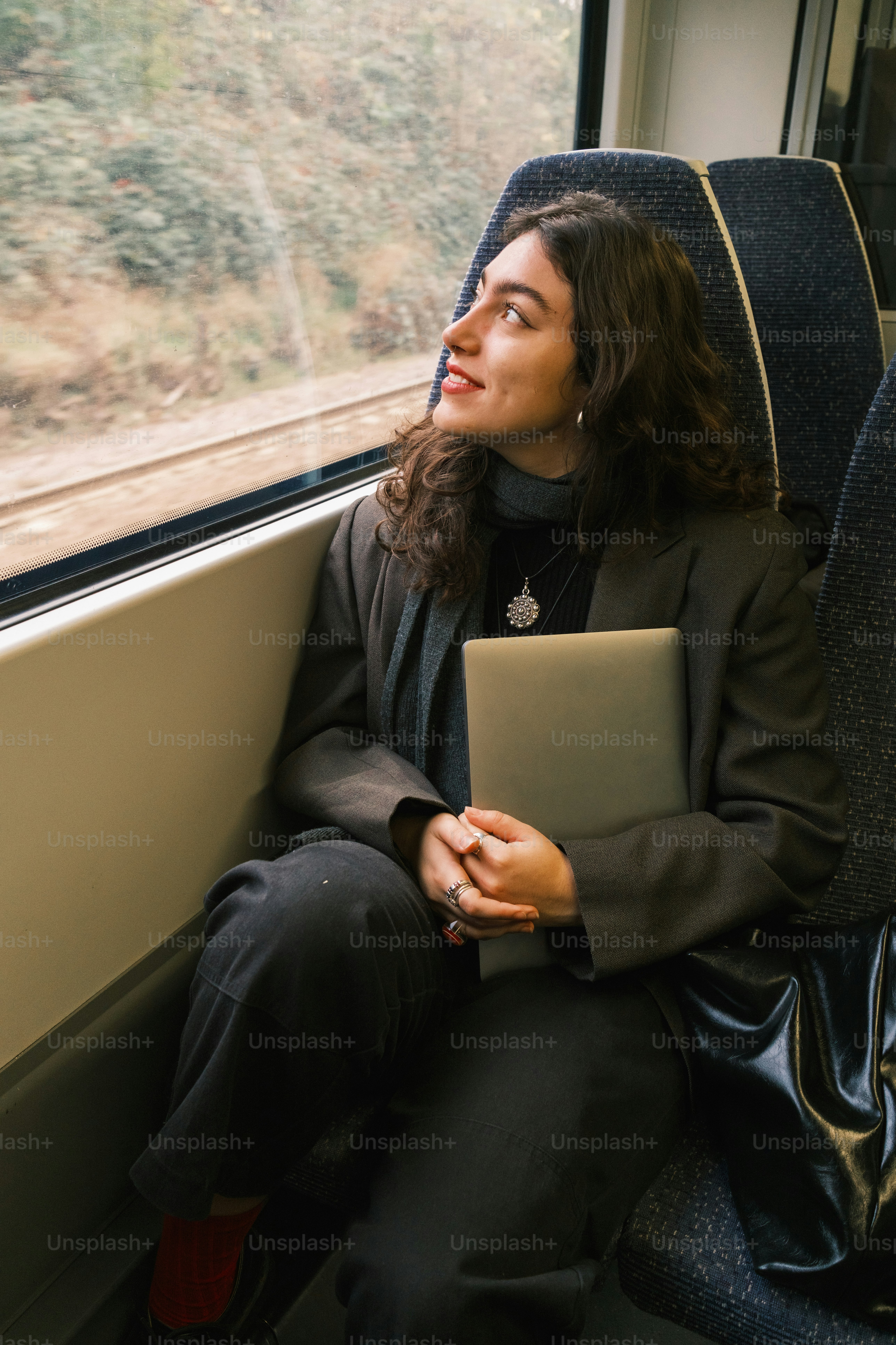 Una mujer sentada en un tren mirando por la ventana