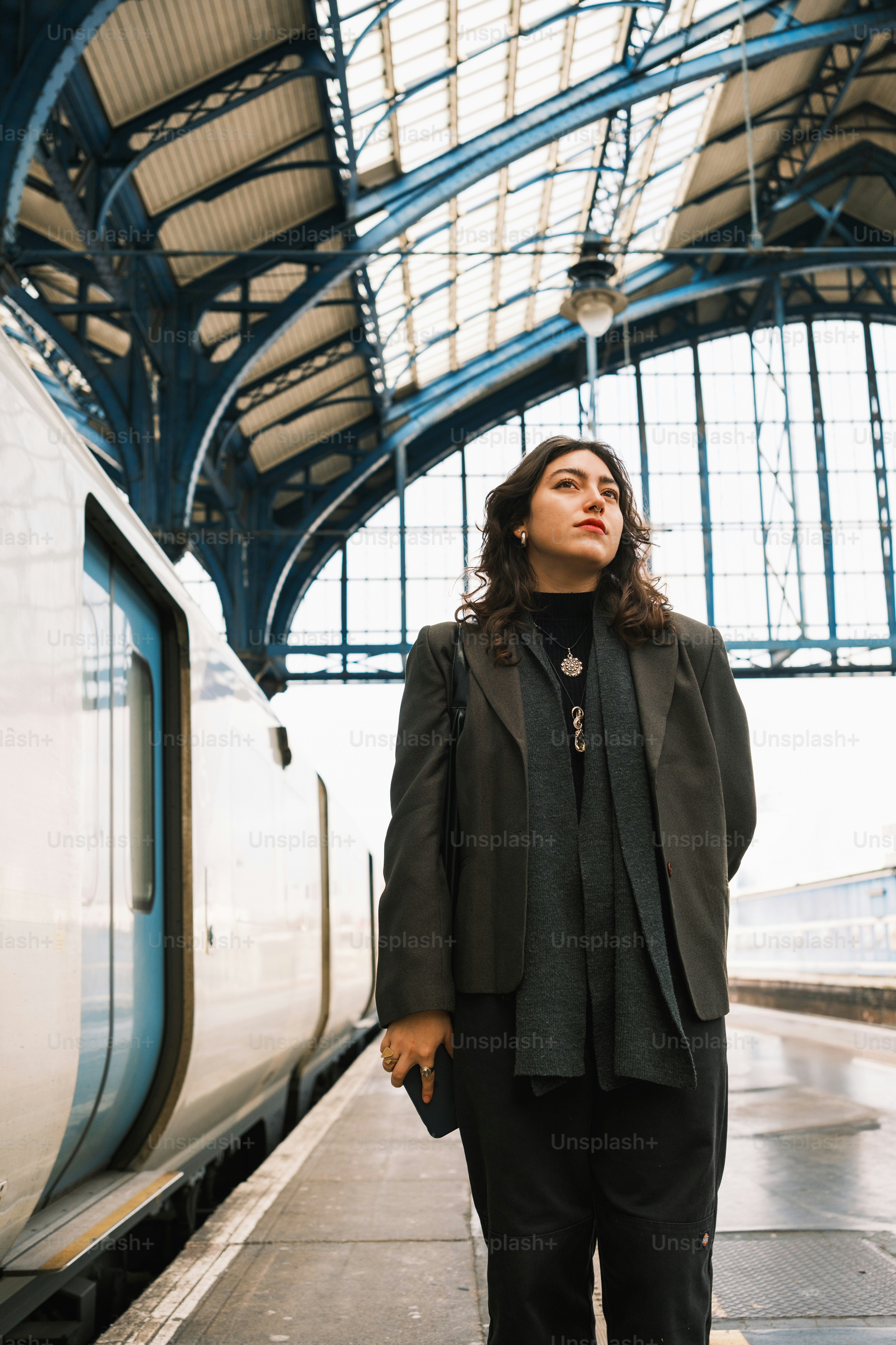 A woman standing in front of a train at a train station