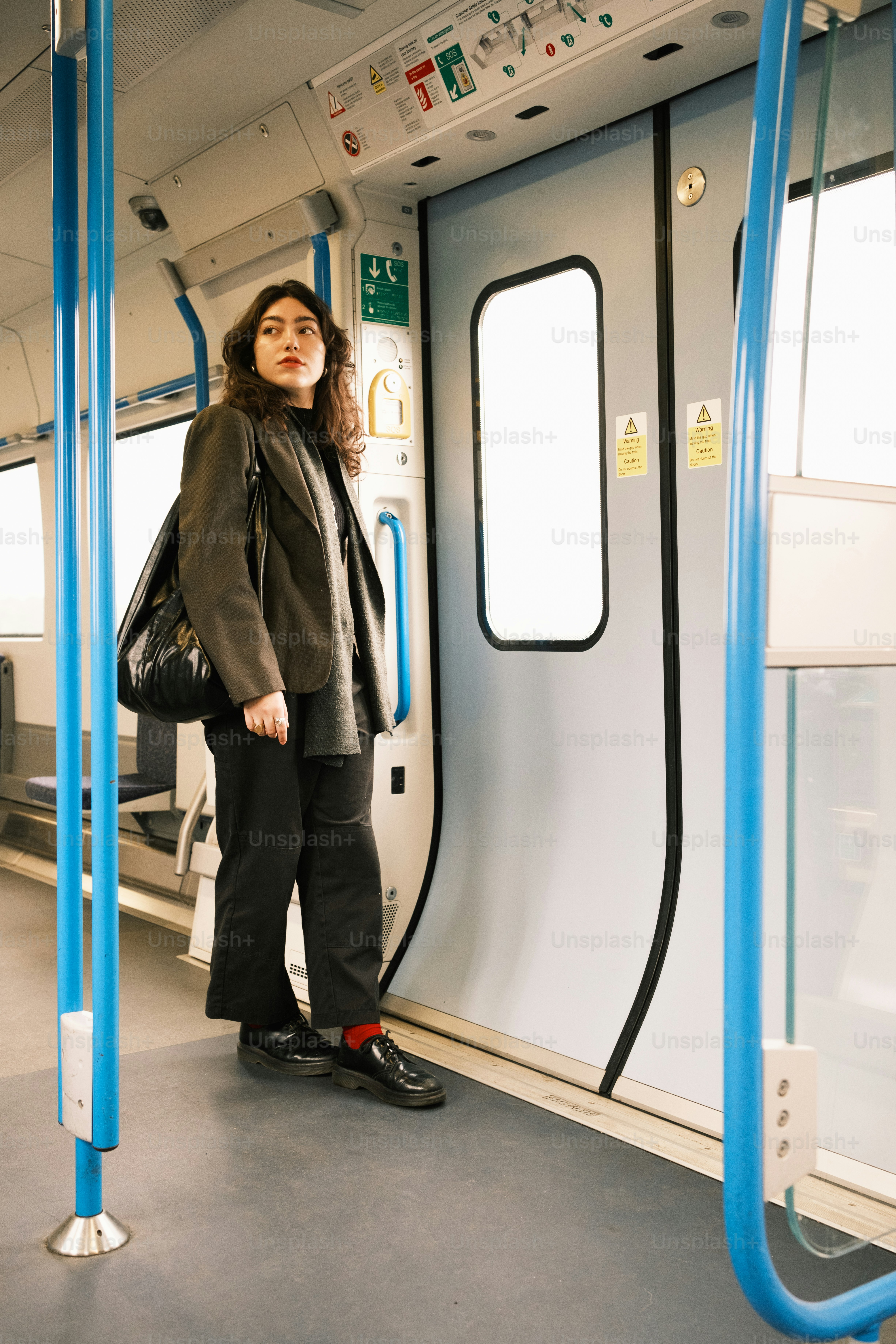 A woman standing on a subway train next to a window
