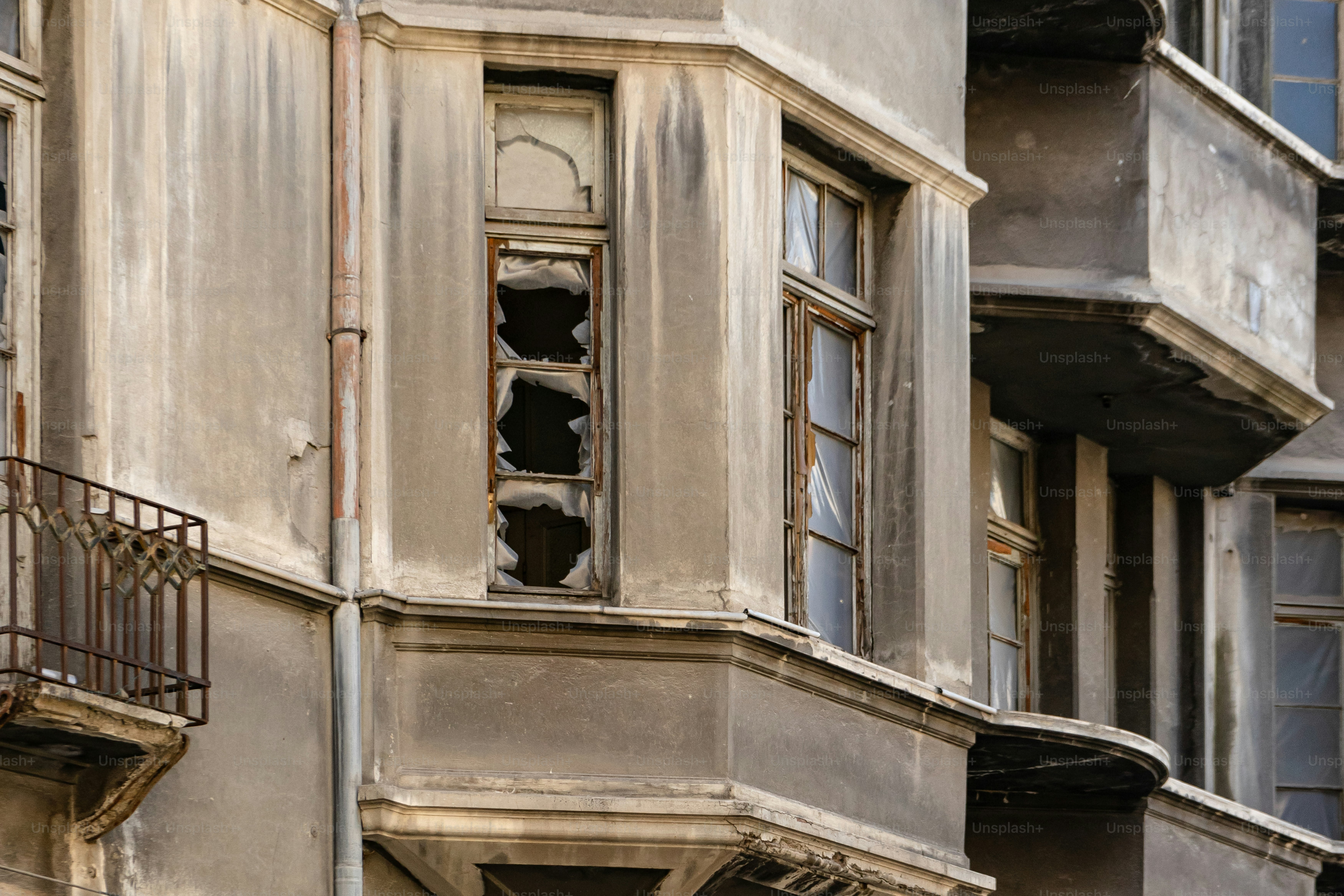 Un vieux bâtiment aux fenêtres et balcons cassés