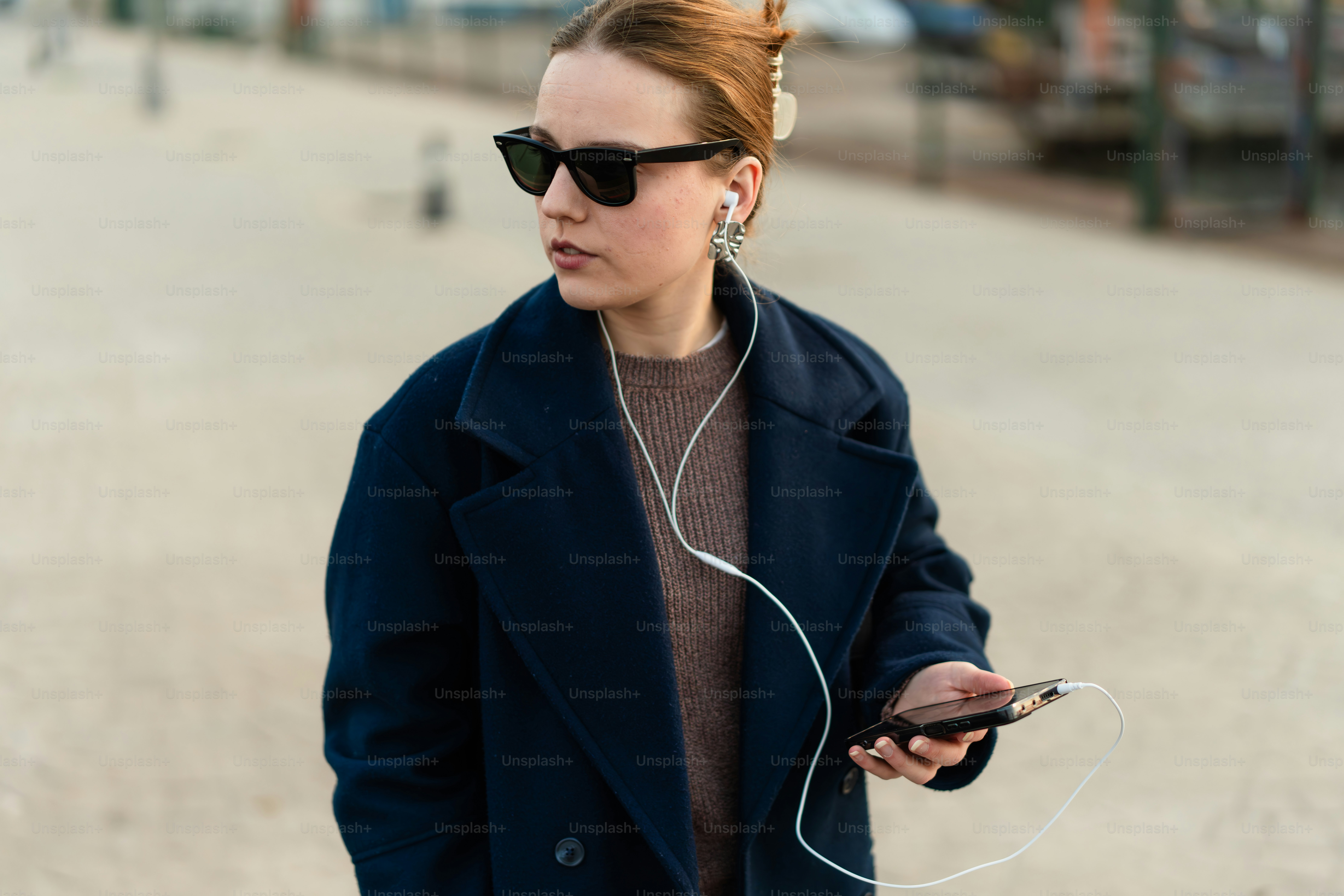 A woman walking down a street while listening to headphones
