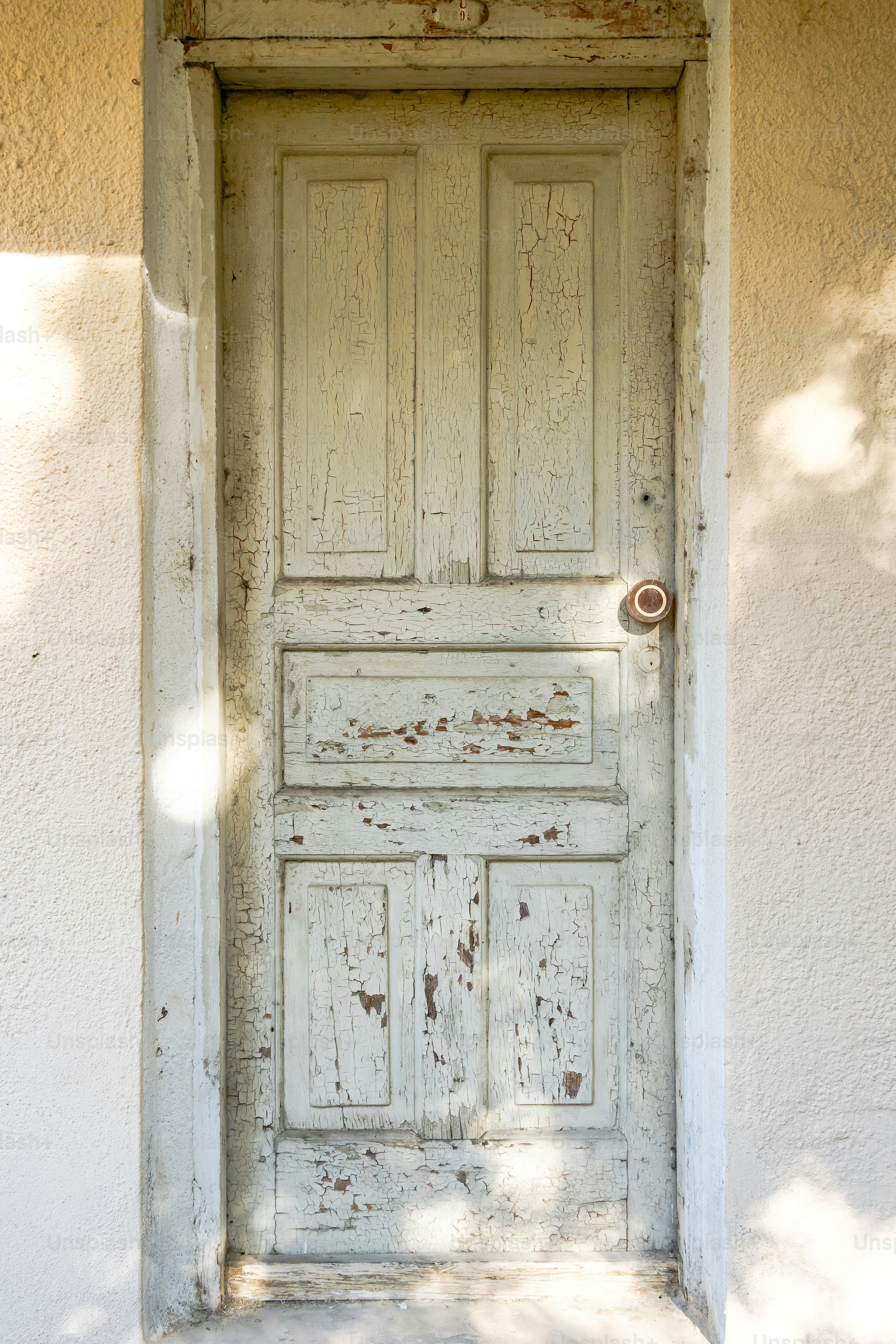 An old white door with a light shining on it