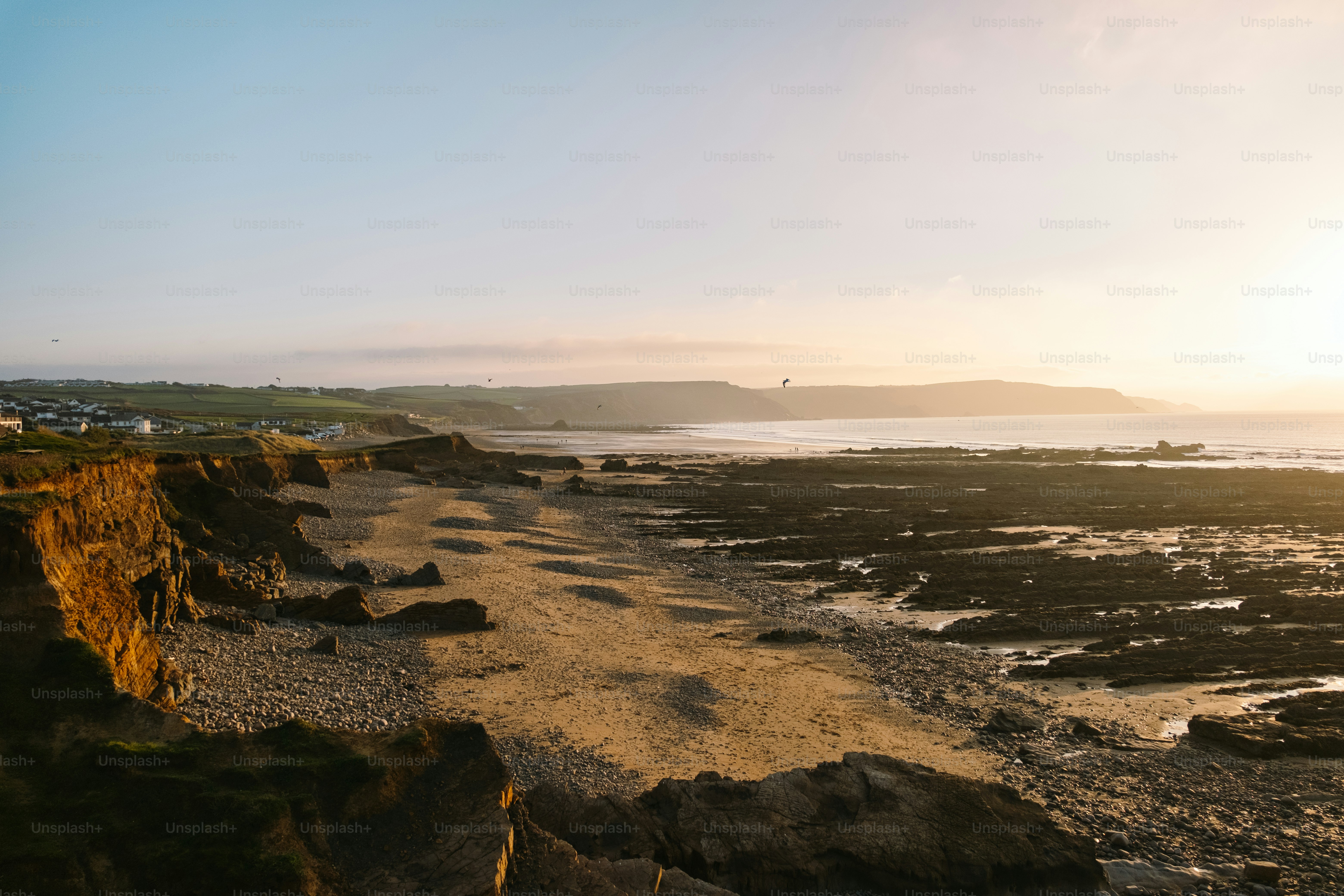 Die Sonne geht über einem felsigen Strand unter