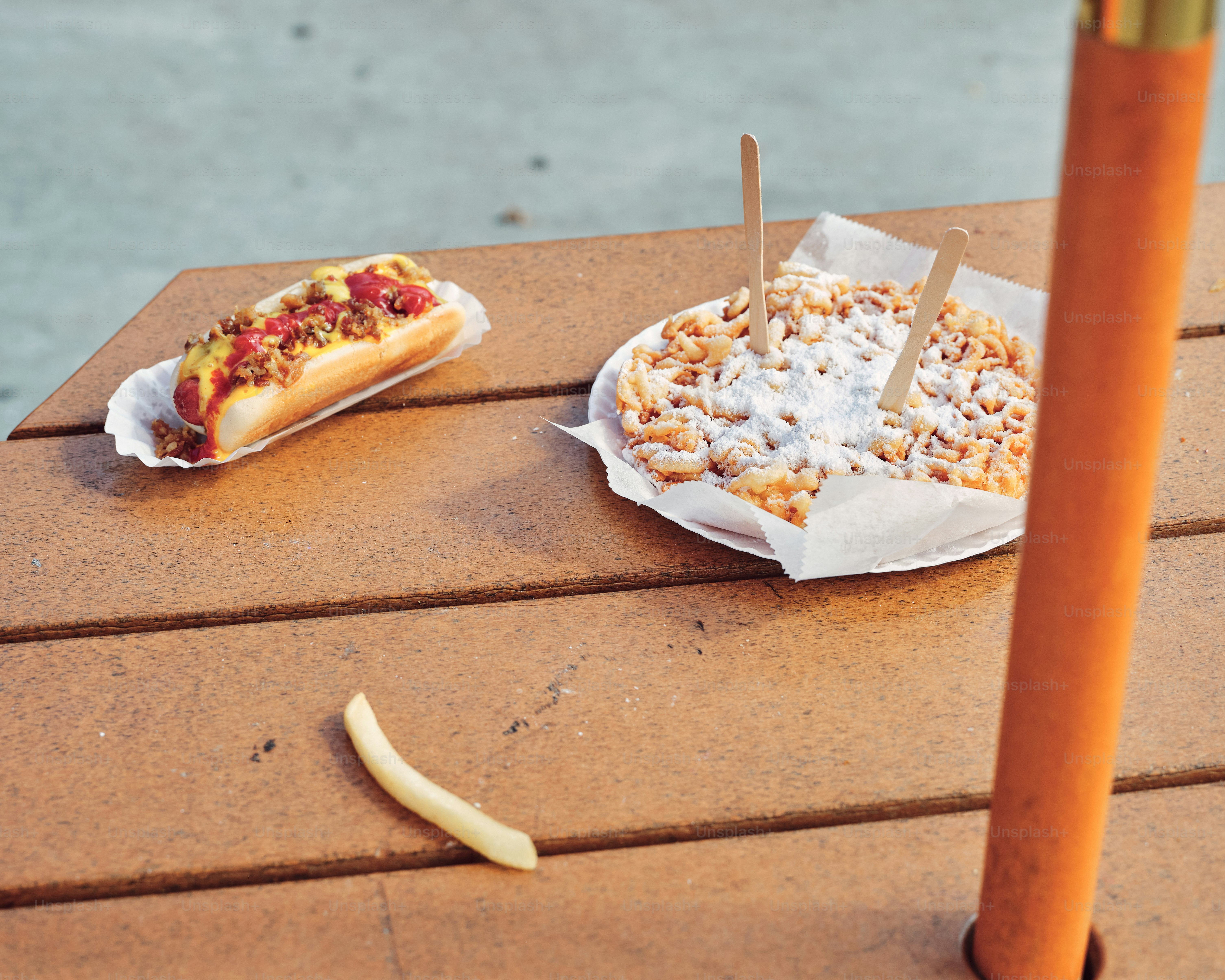 A hot dog and a banana on a picnic table