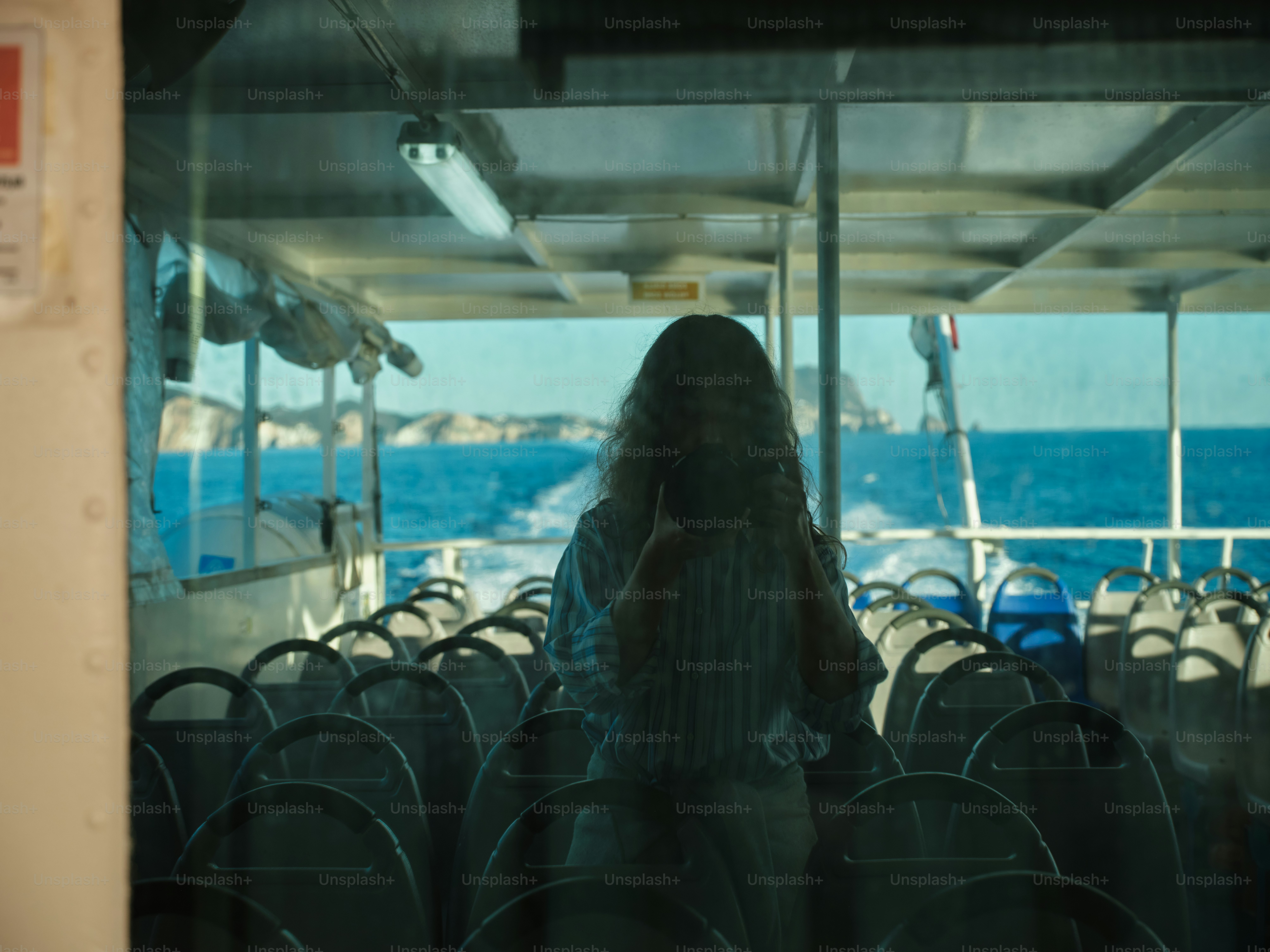 A woman sitting on a boat looking out the window