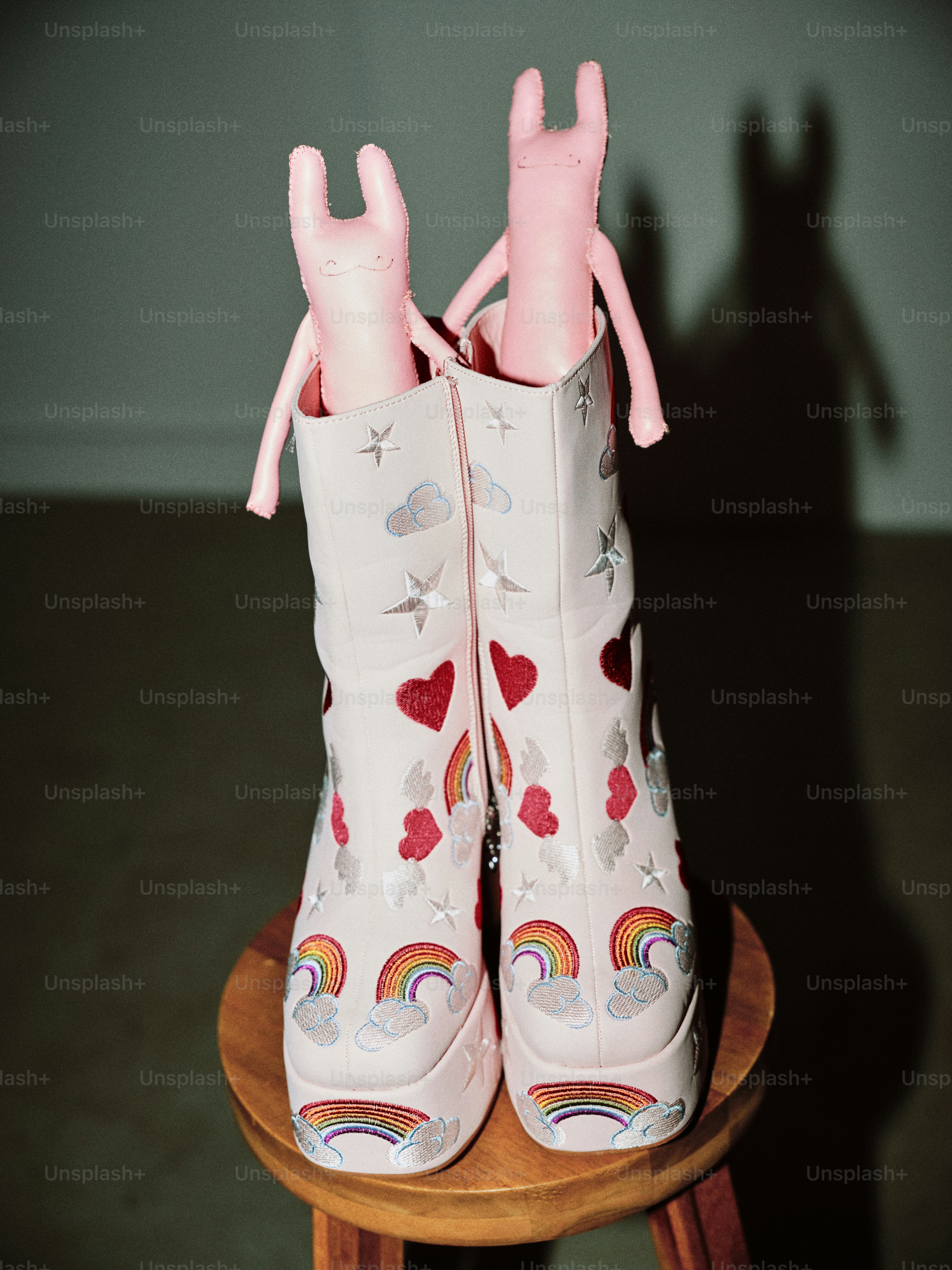 Un par de botas blancas con corazones y arcoíris
