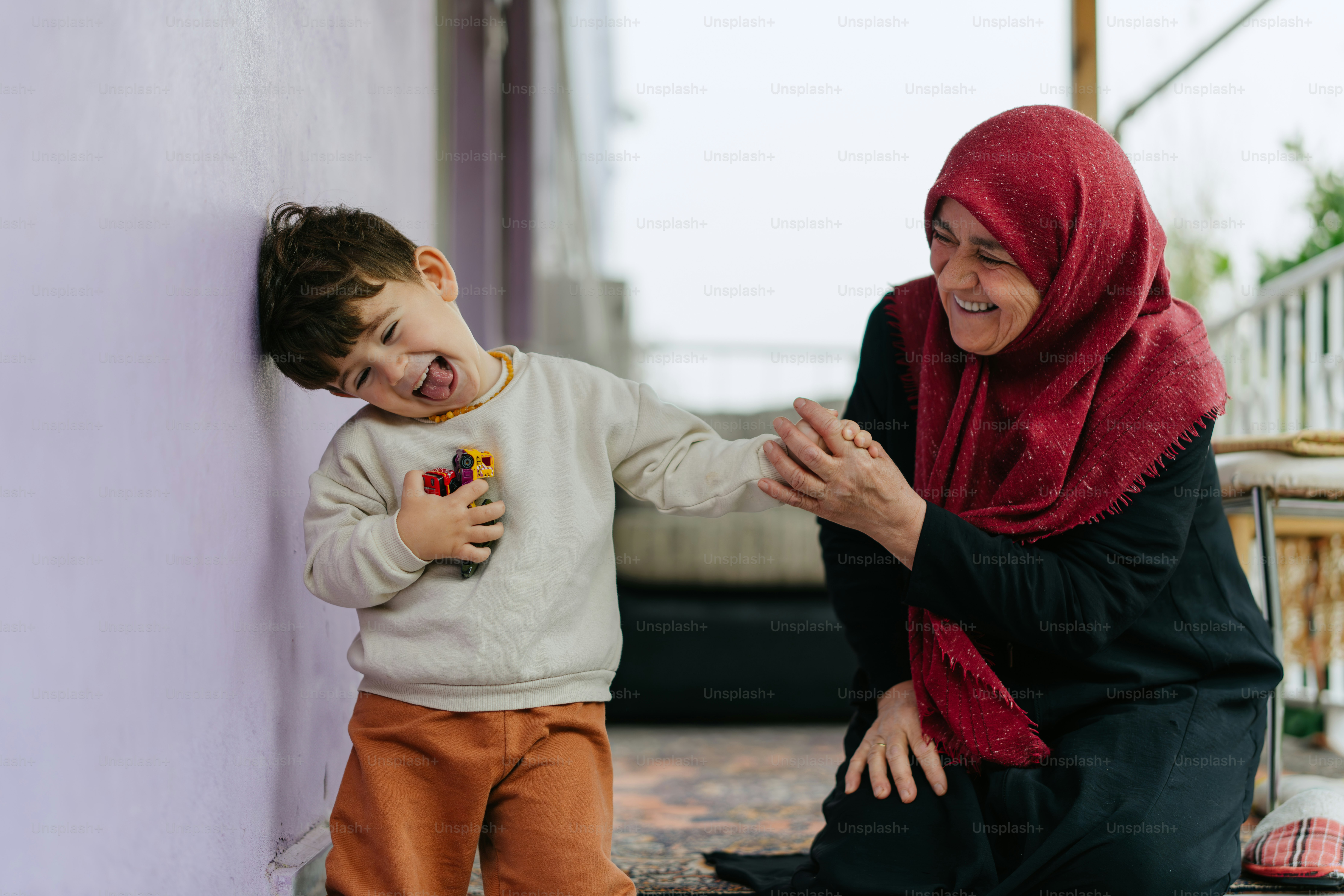 A woman kneeling down next to a little boy