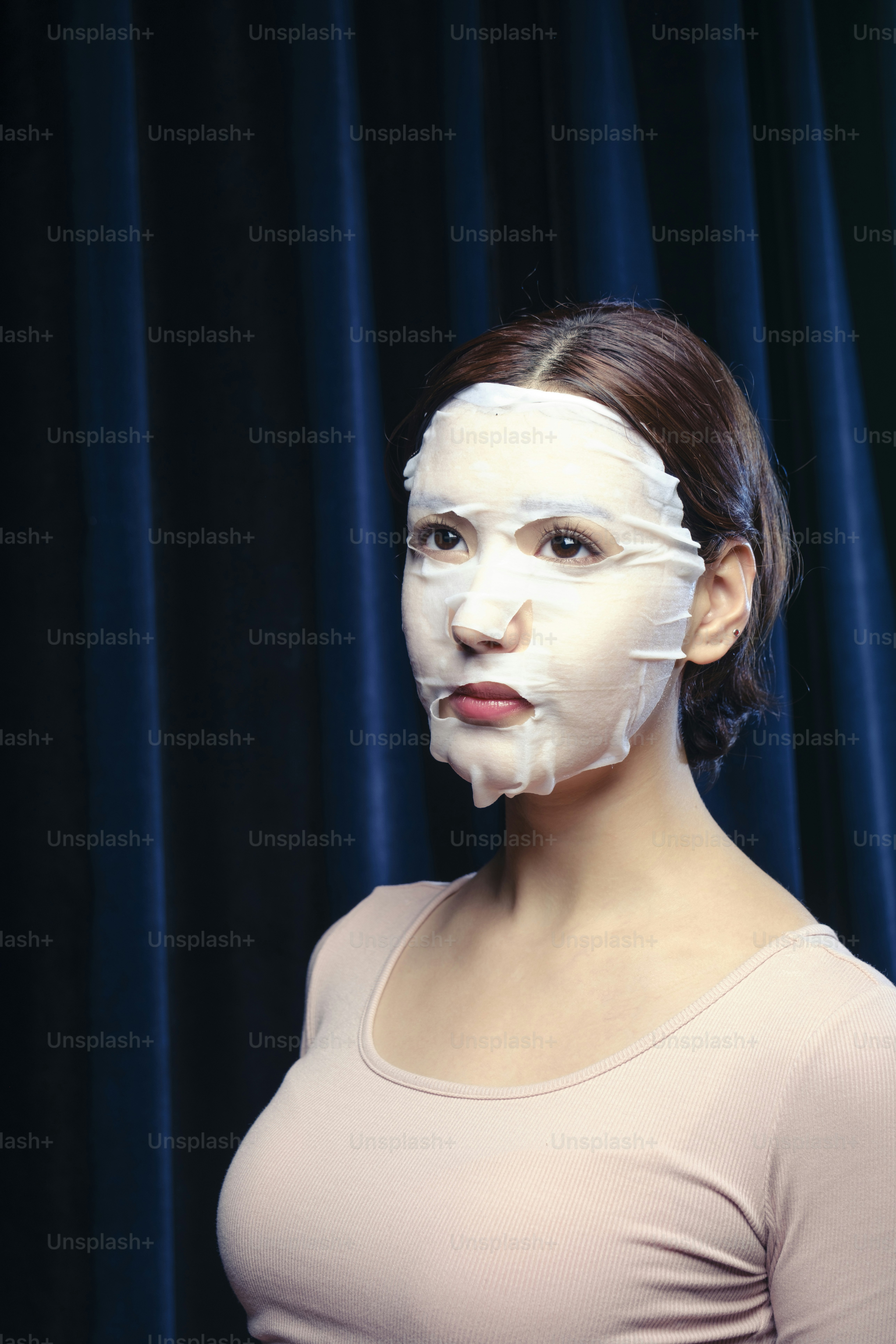 A woman with a sheet of paper on her face