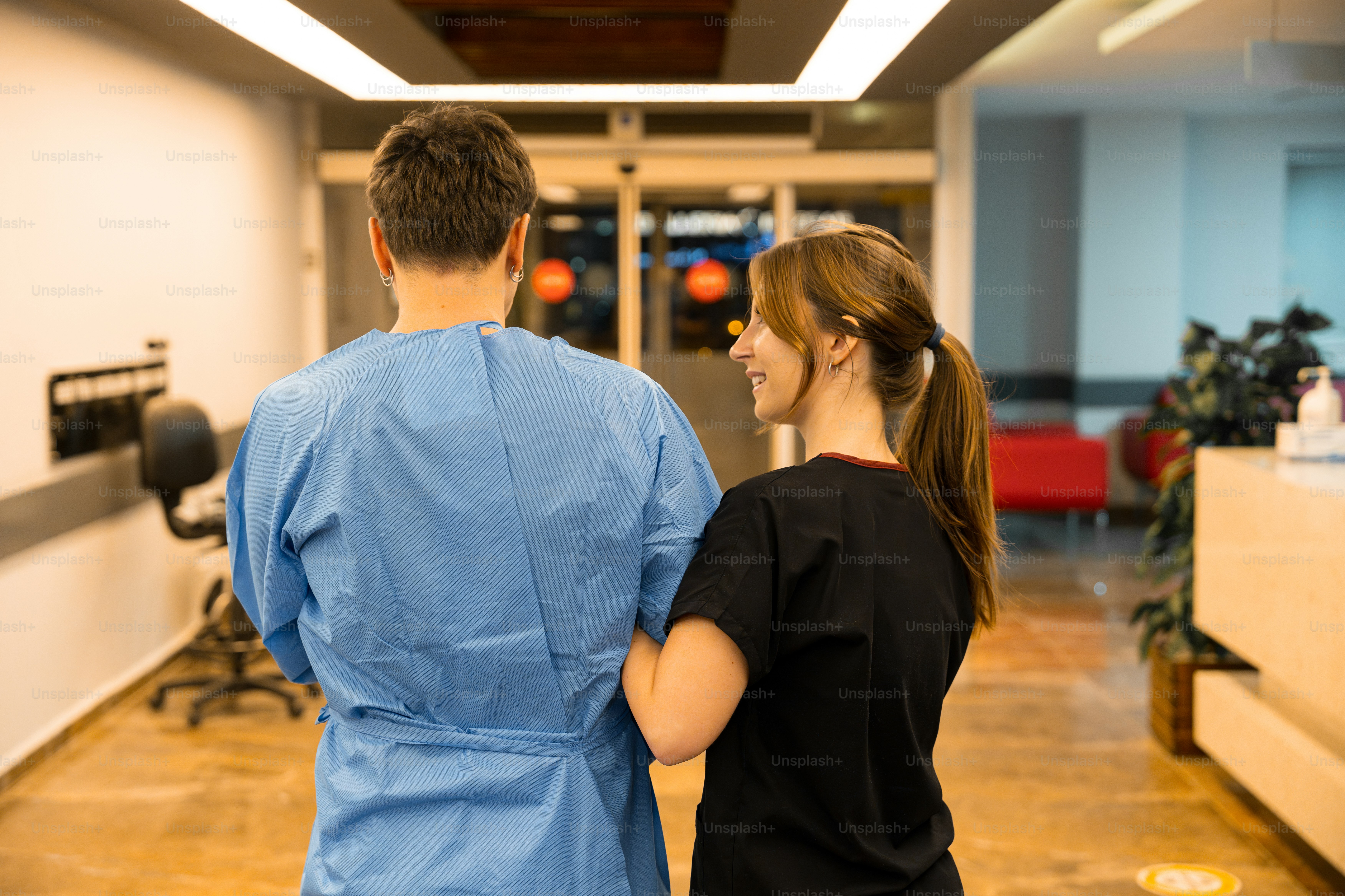 Nurse and administrator reviewing a tablet in a care facility corridor