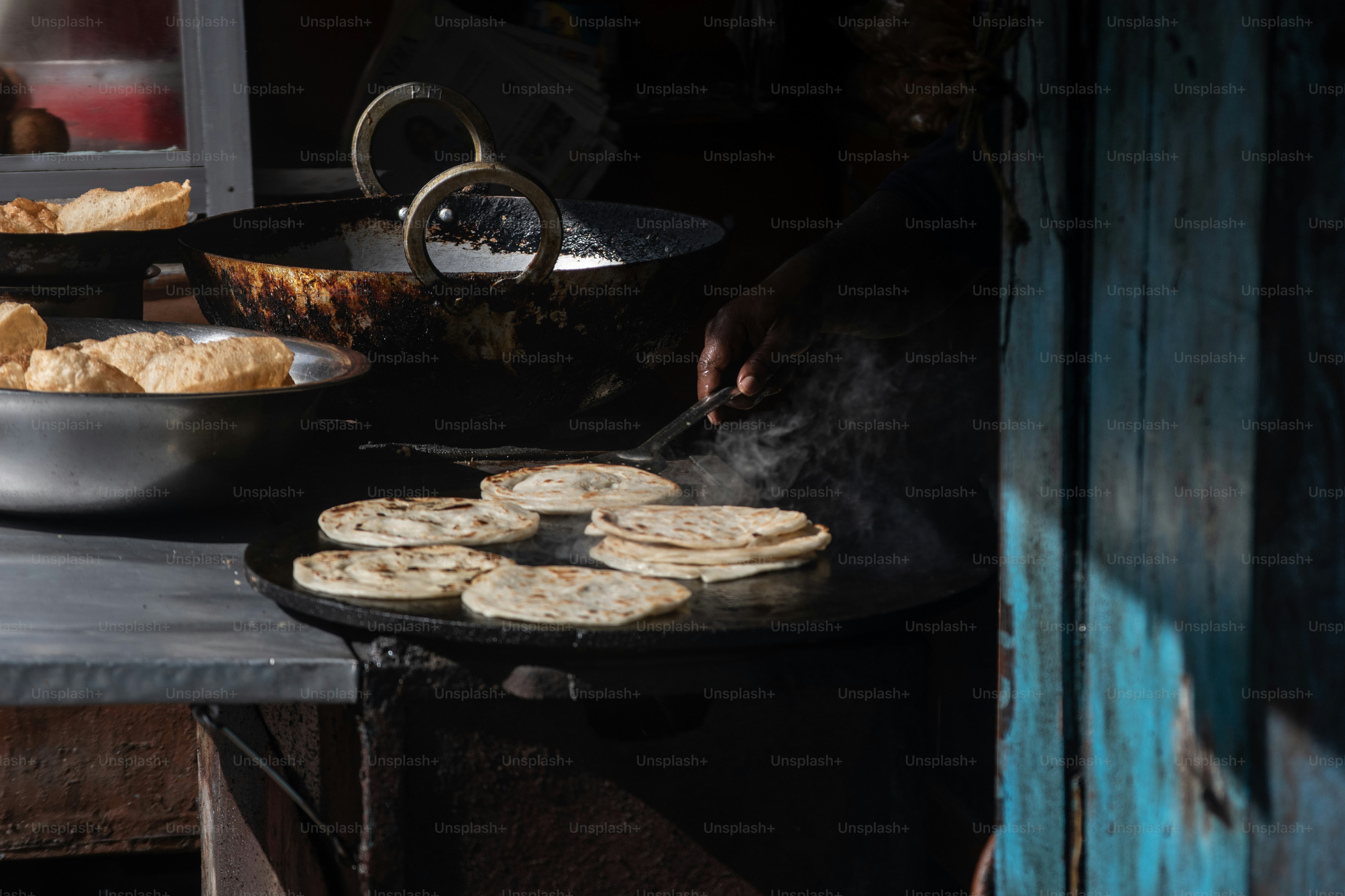 A person cooking food on a stove in a kitchen