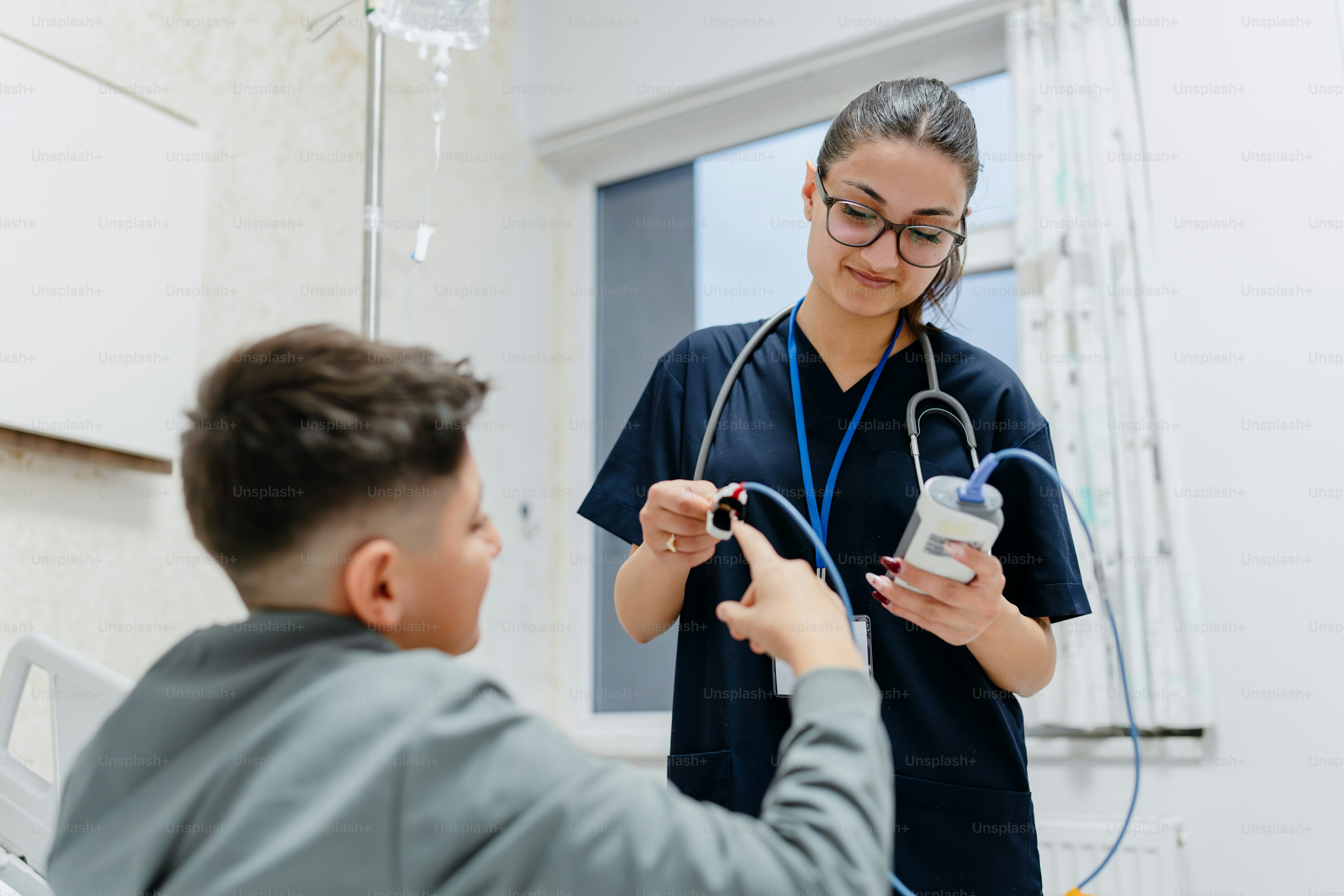 スクラブを着た女性が聴診器を持って男性の話を聞いています