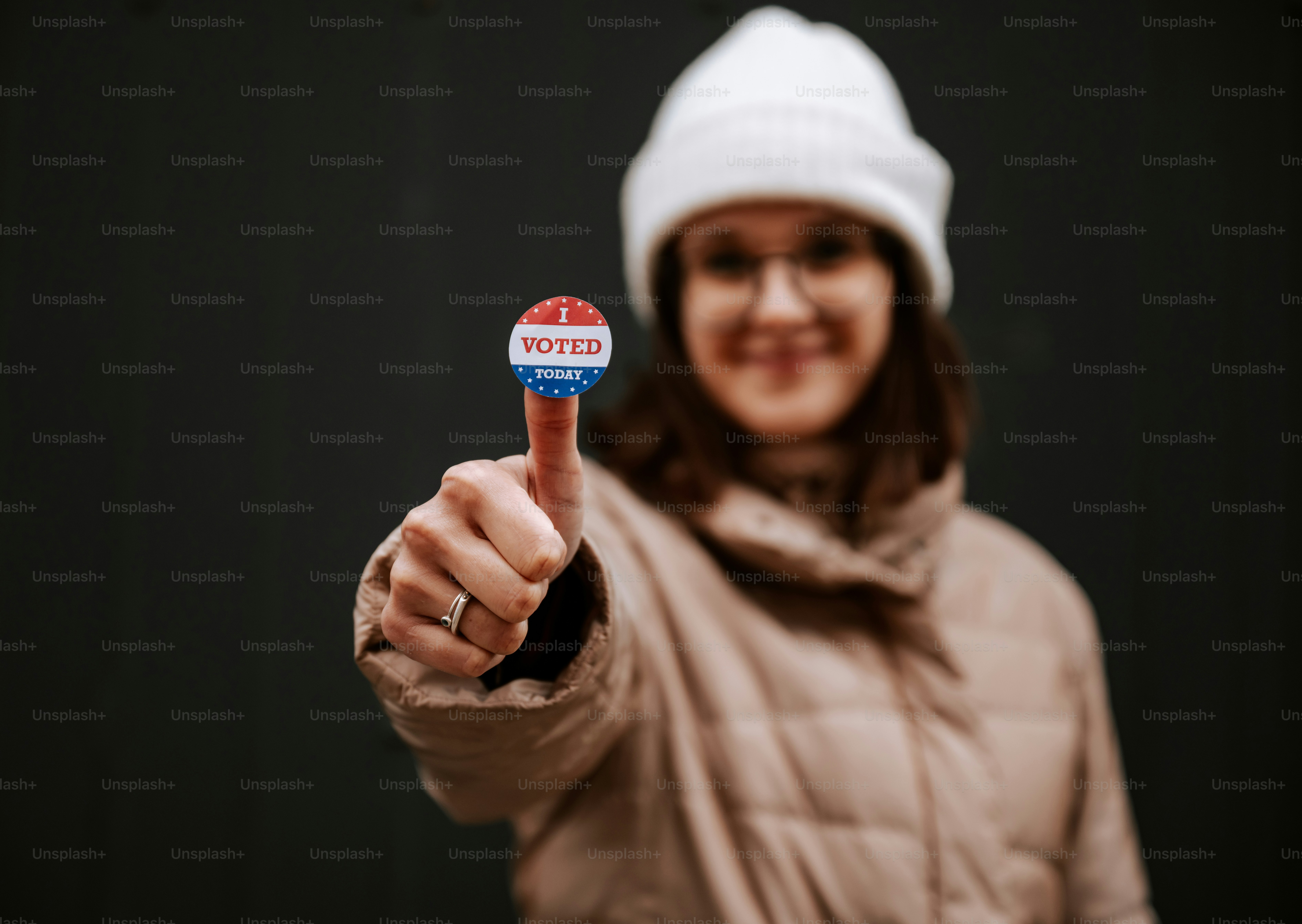 A woman pointing at the camera with a button on her finger