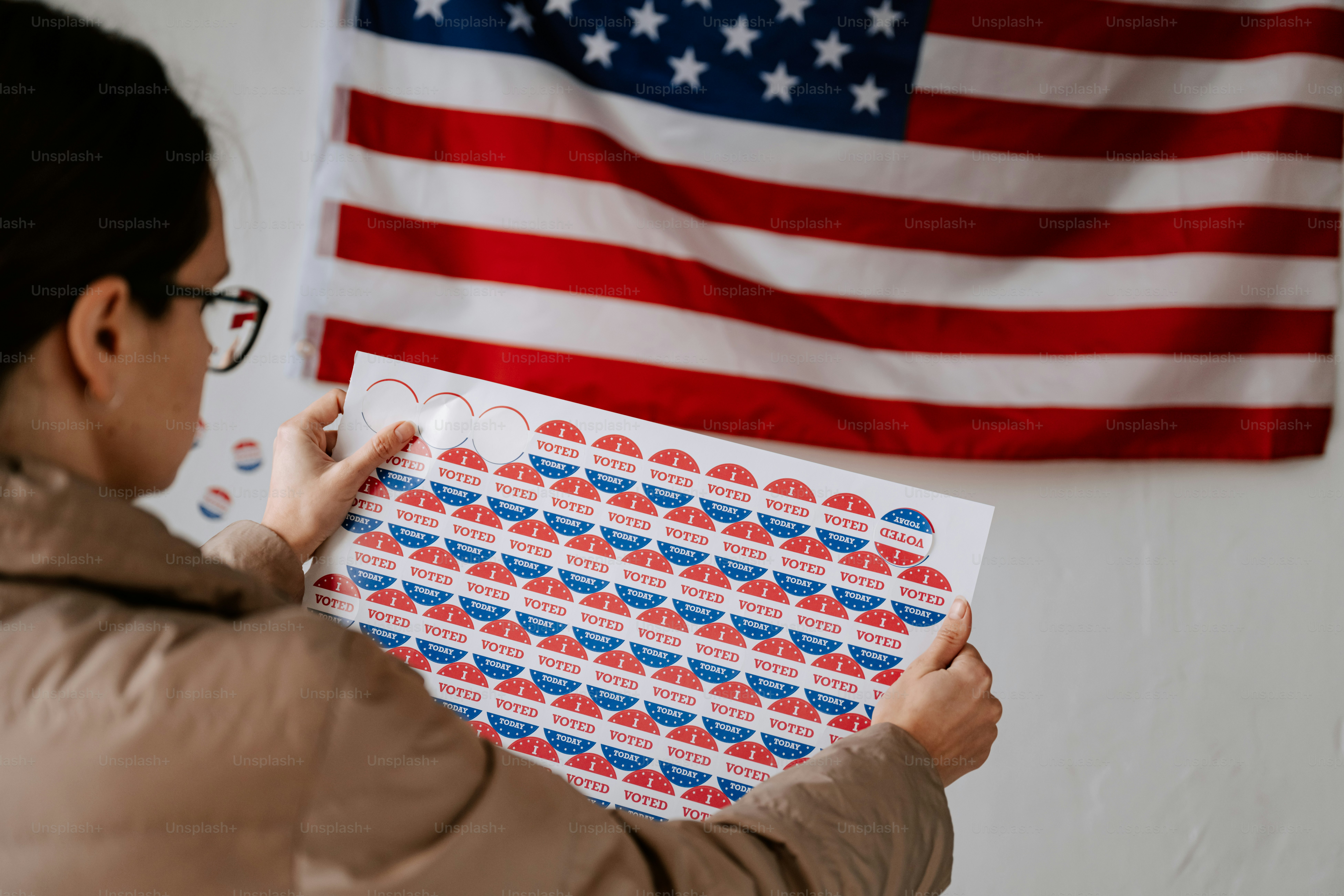 A woman standing in front of a voting booth photo – American flag Image ...