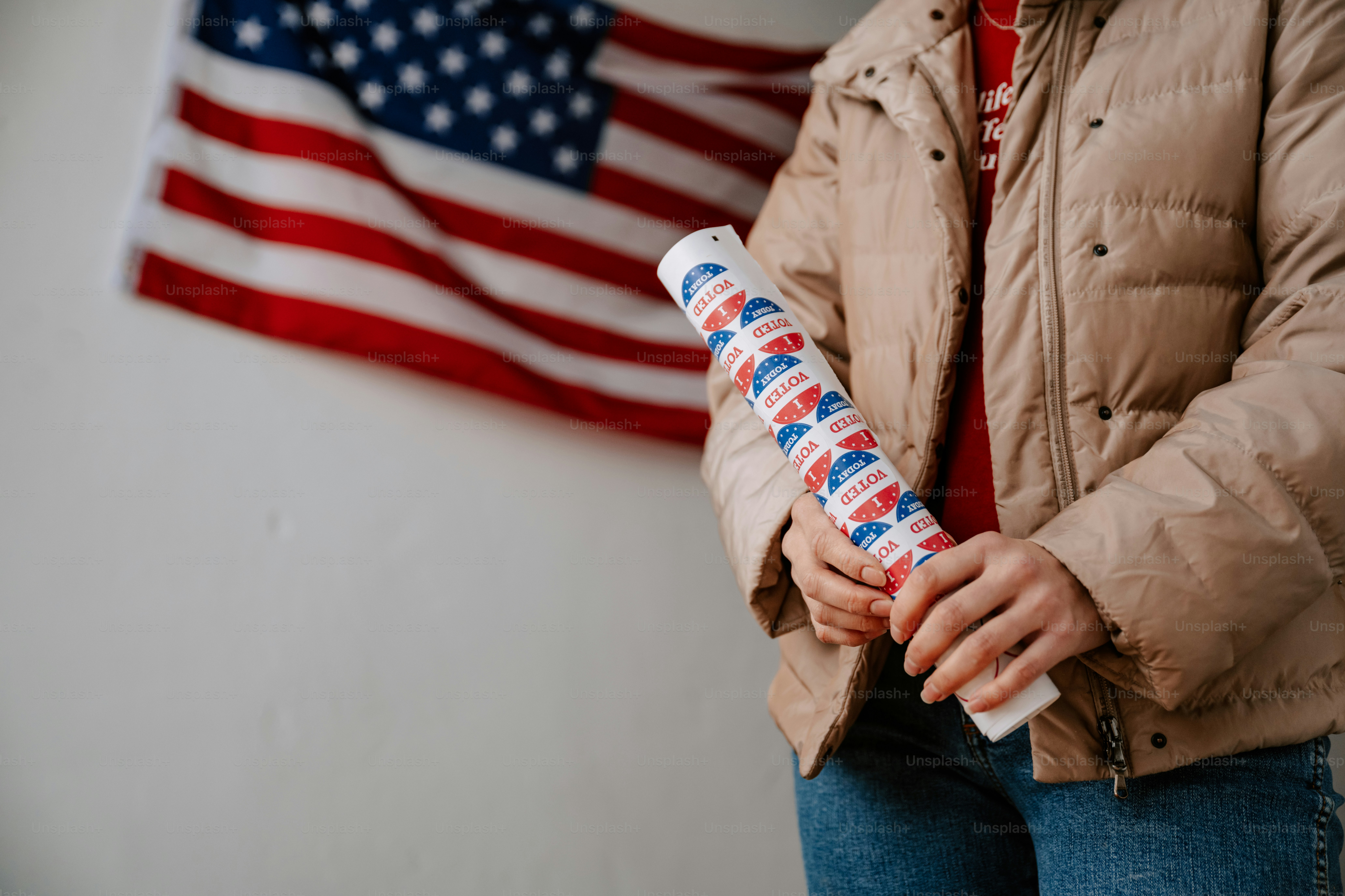 A woman standing in front of an american flag