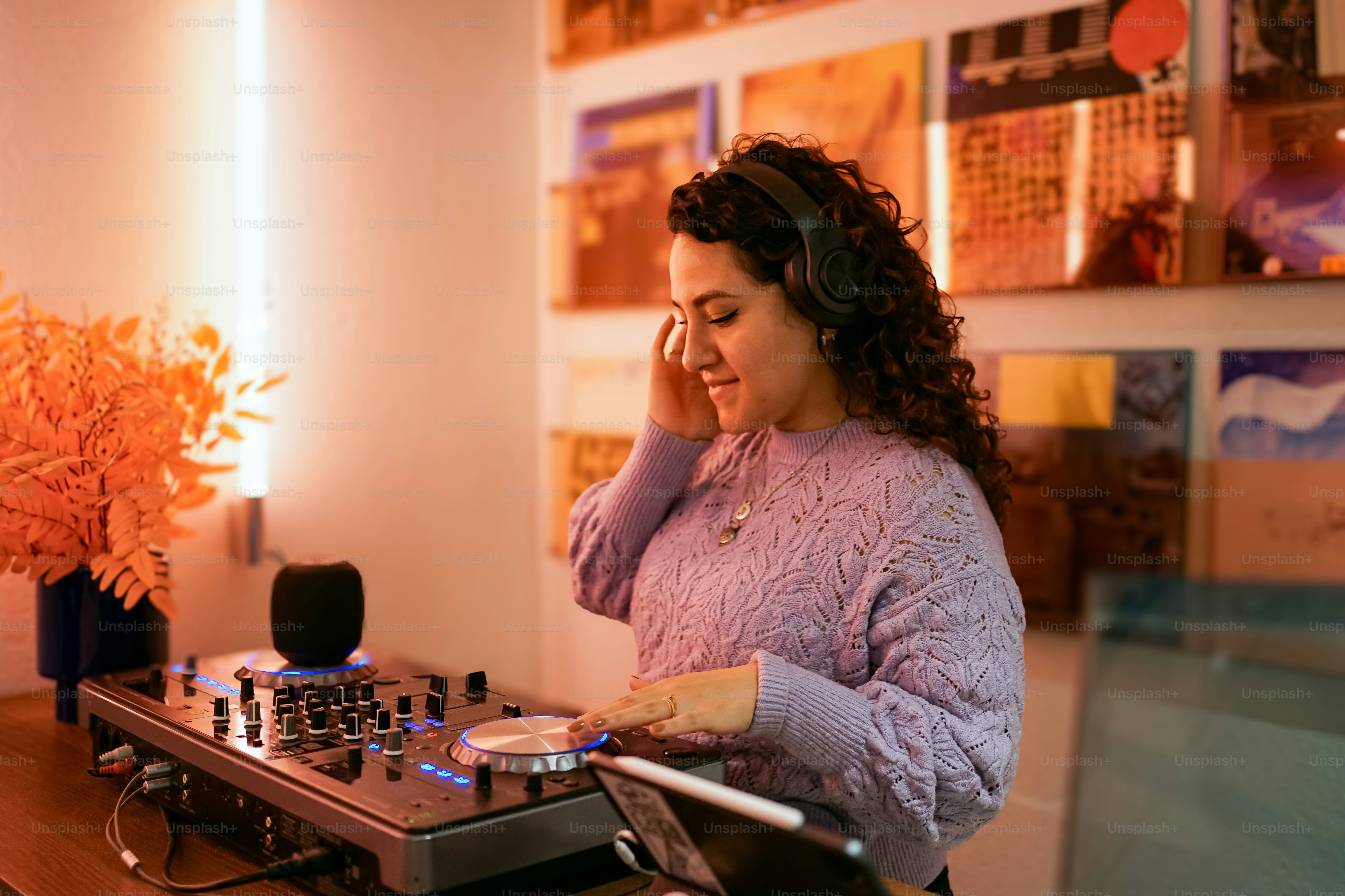 Una mujer de pie frente a la mesa de mezclas de un dj