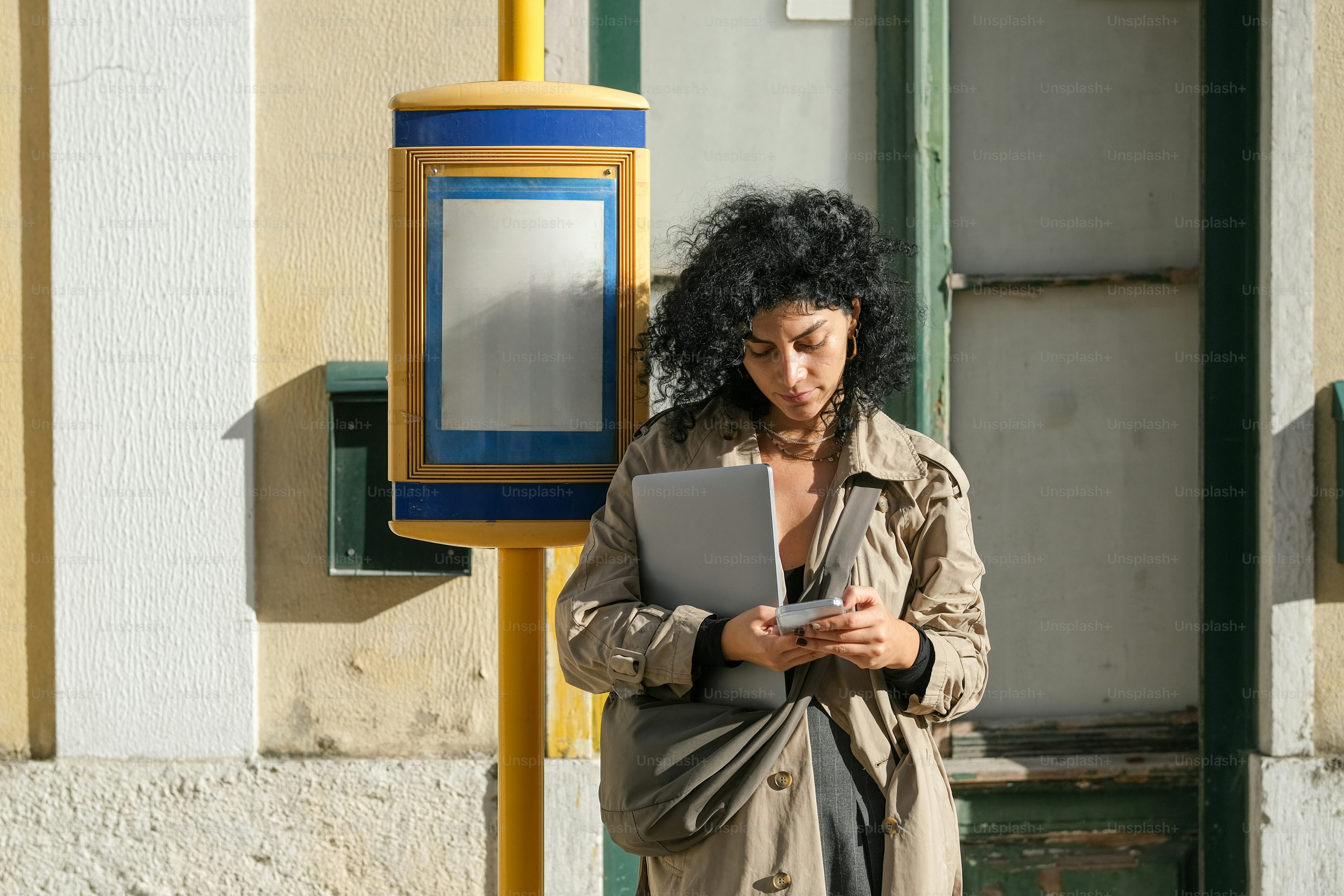 A woman standing next to a pole with a laptop
