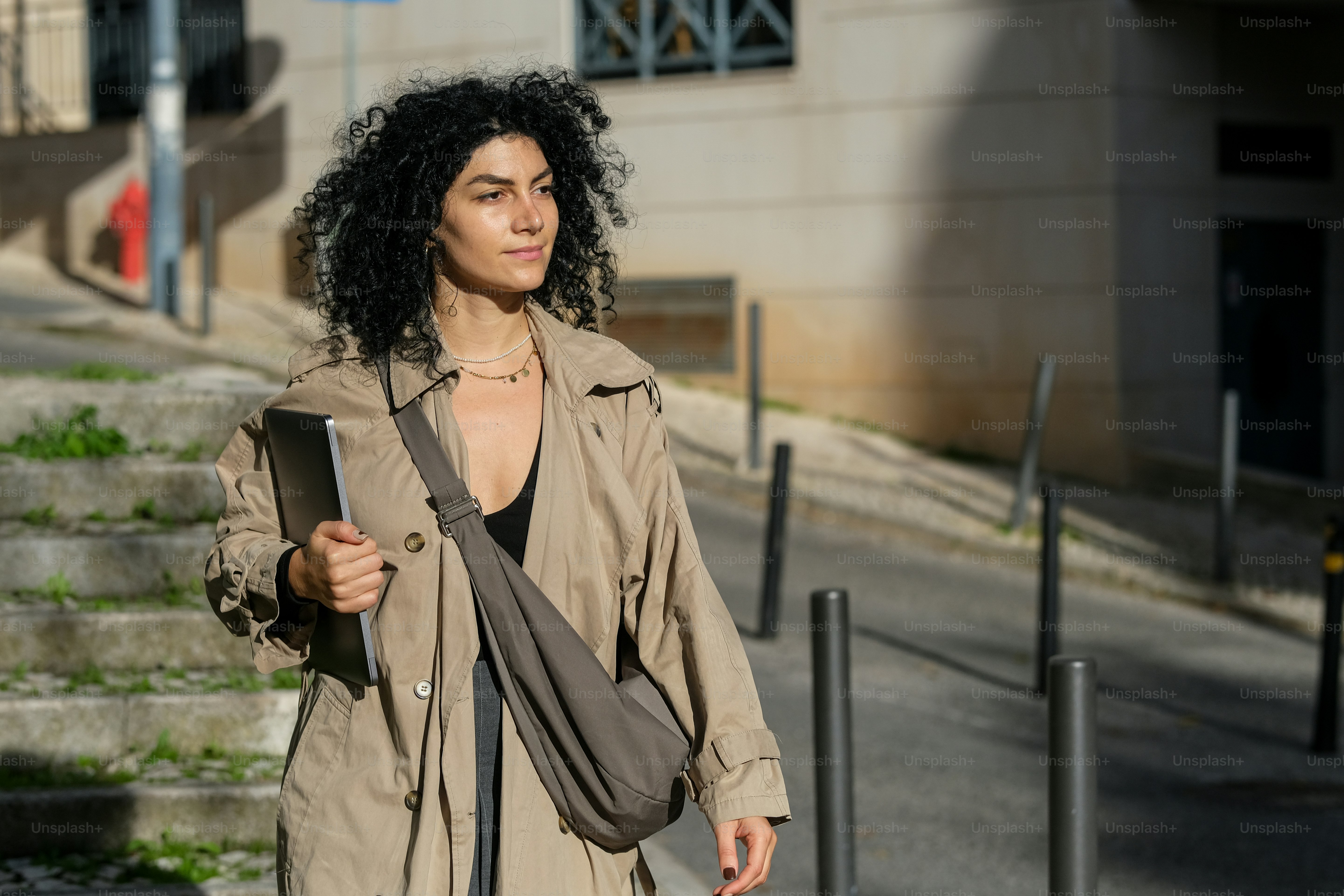 A woman is walking down the street with her luggage