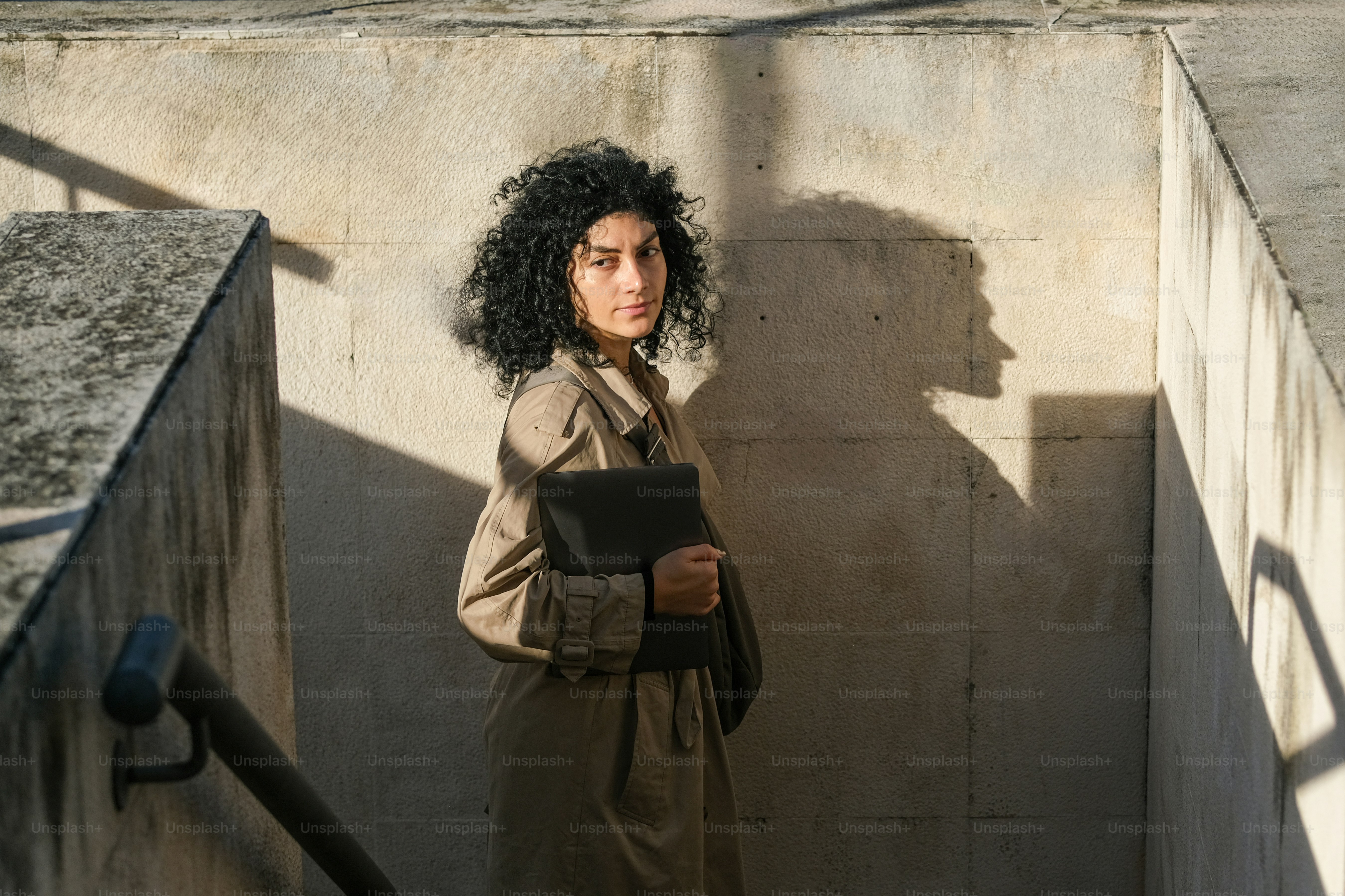 A woman standing in a corner with a book in her hand