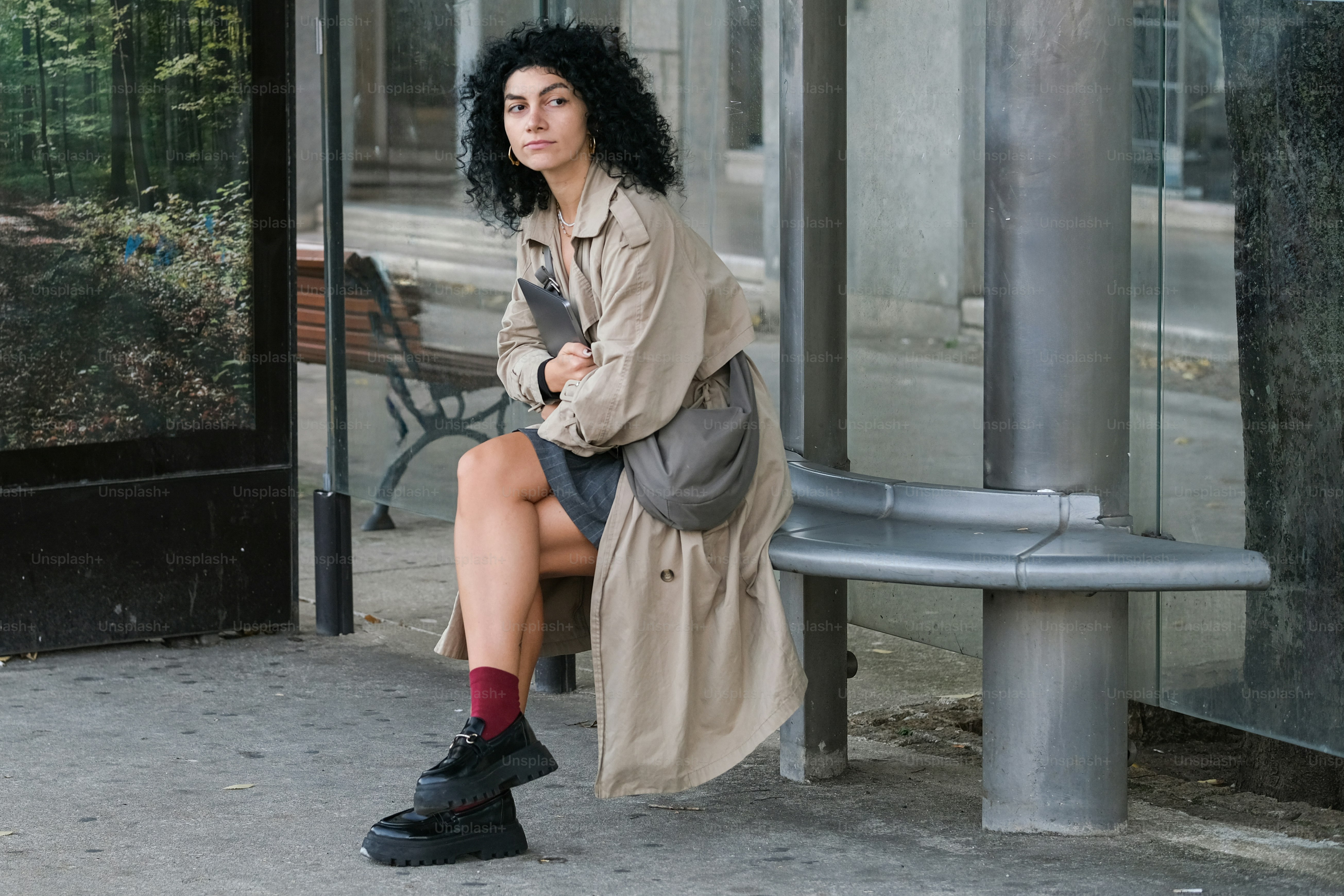 A woman sitting on a bench in front of a building