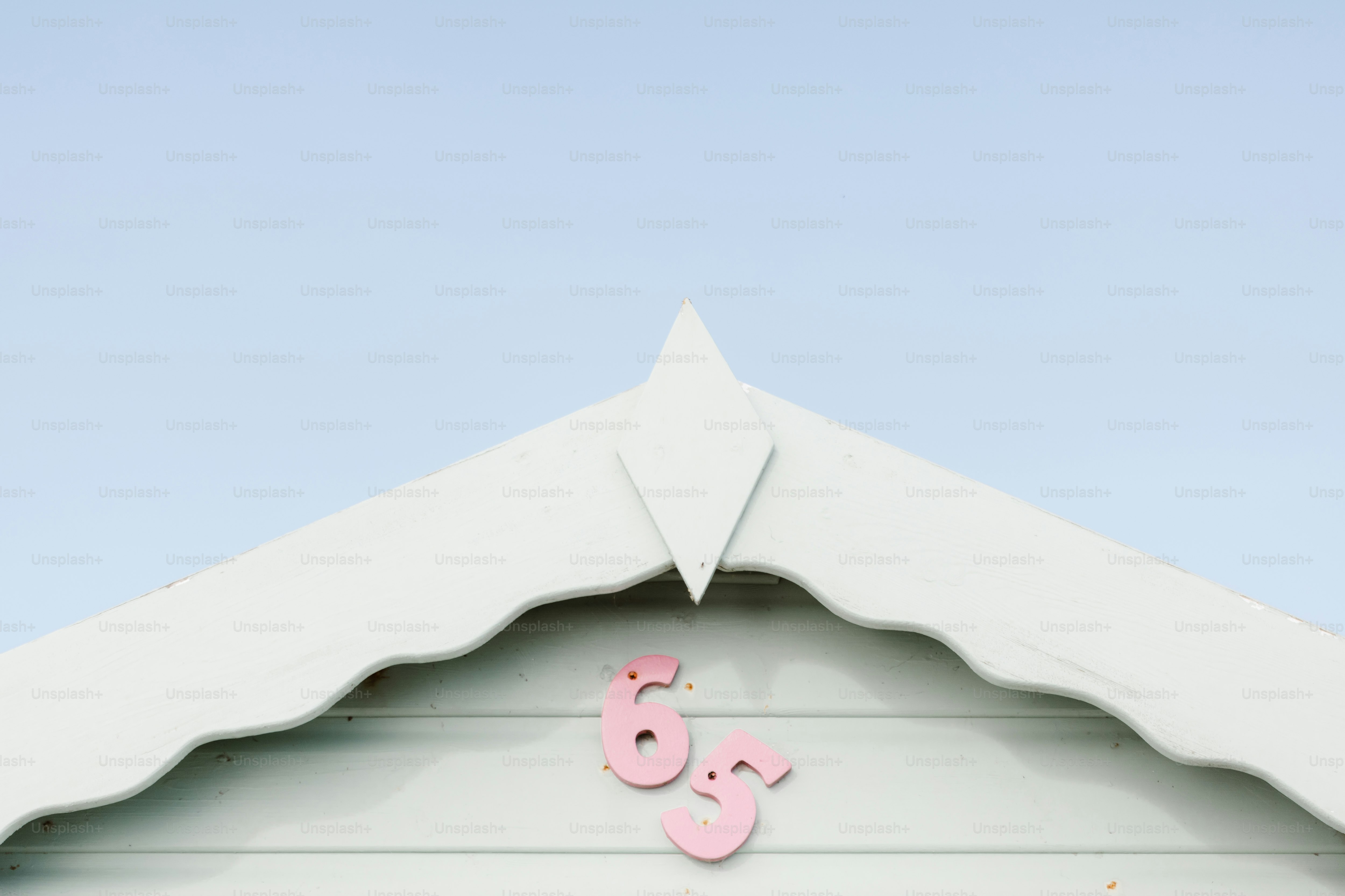 A white building with a pink and white sign on it