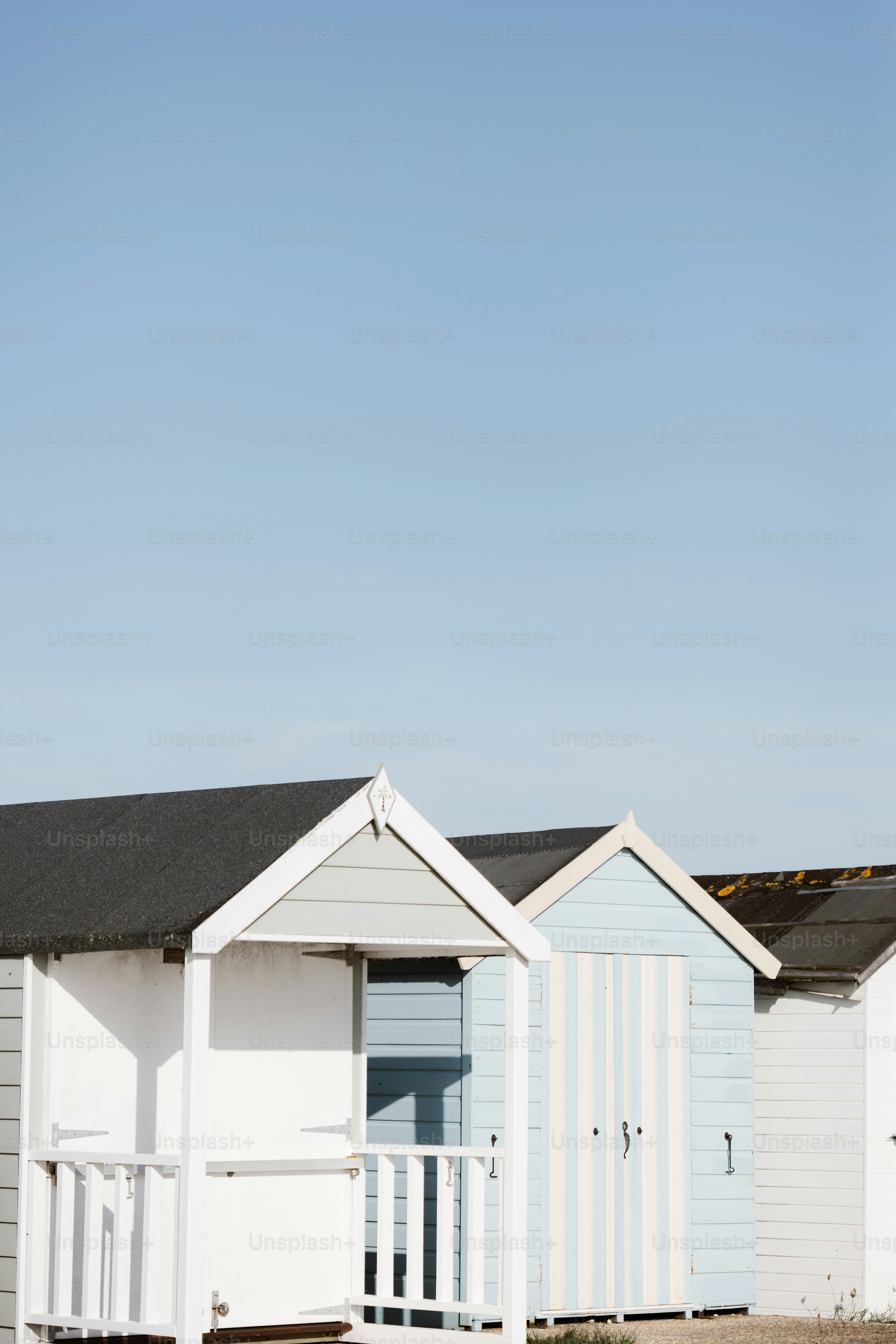 Uma fileira de cabanas de praia sentadas uma ao lado da outra