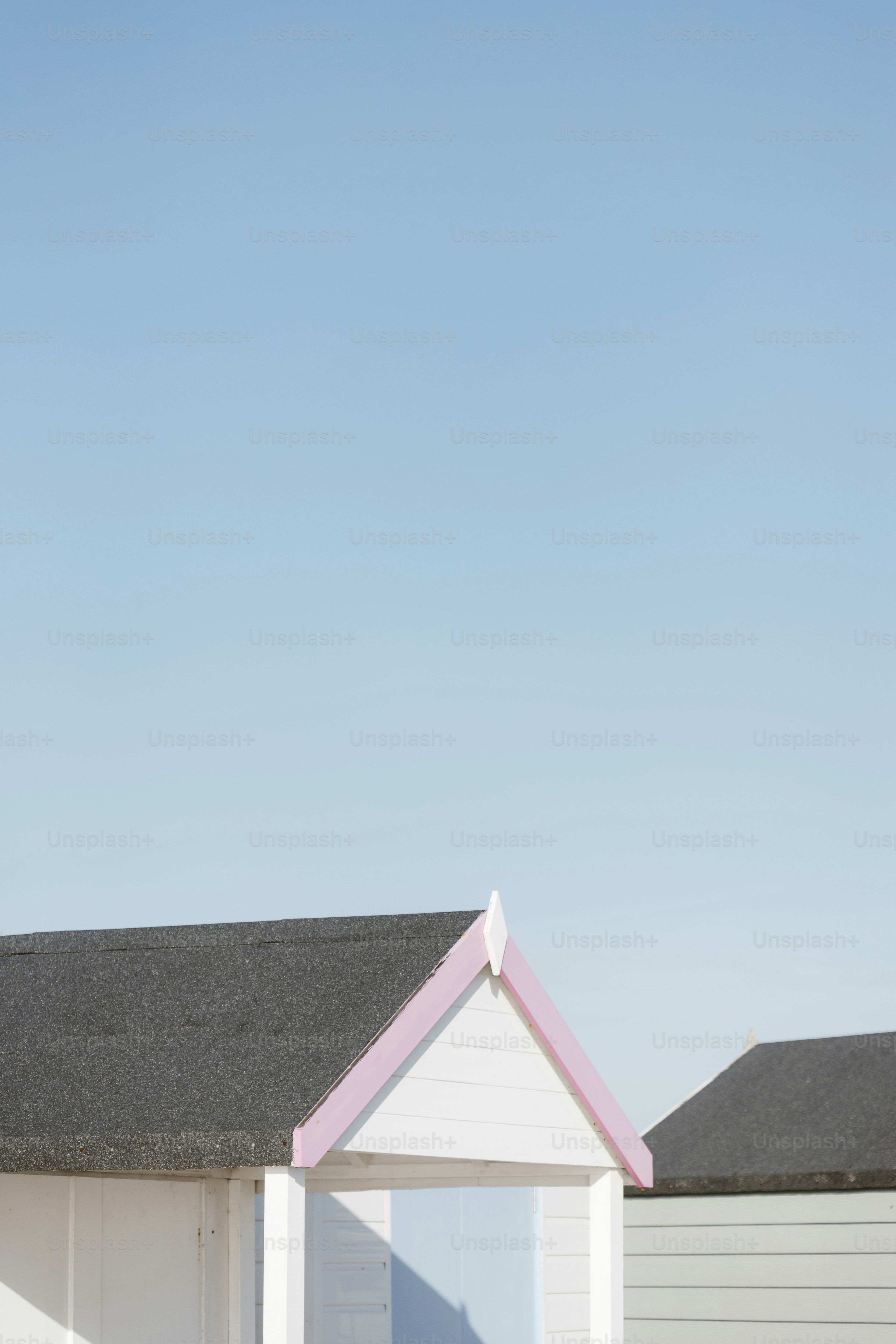 Uma fileira de casas brancas com um telhado rosa