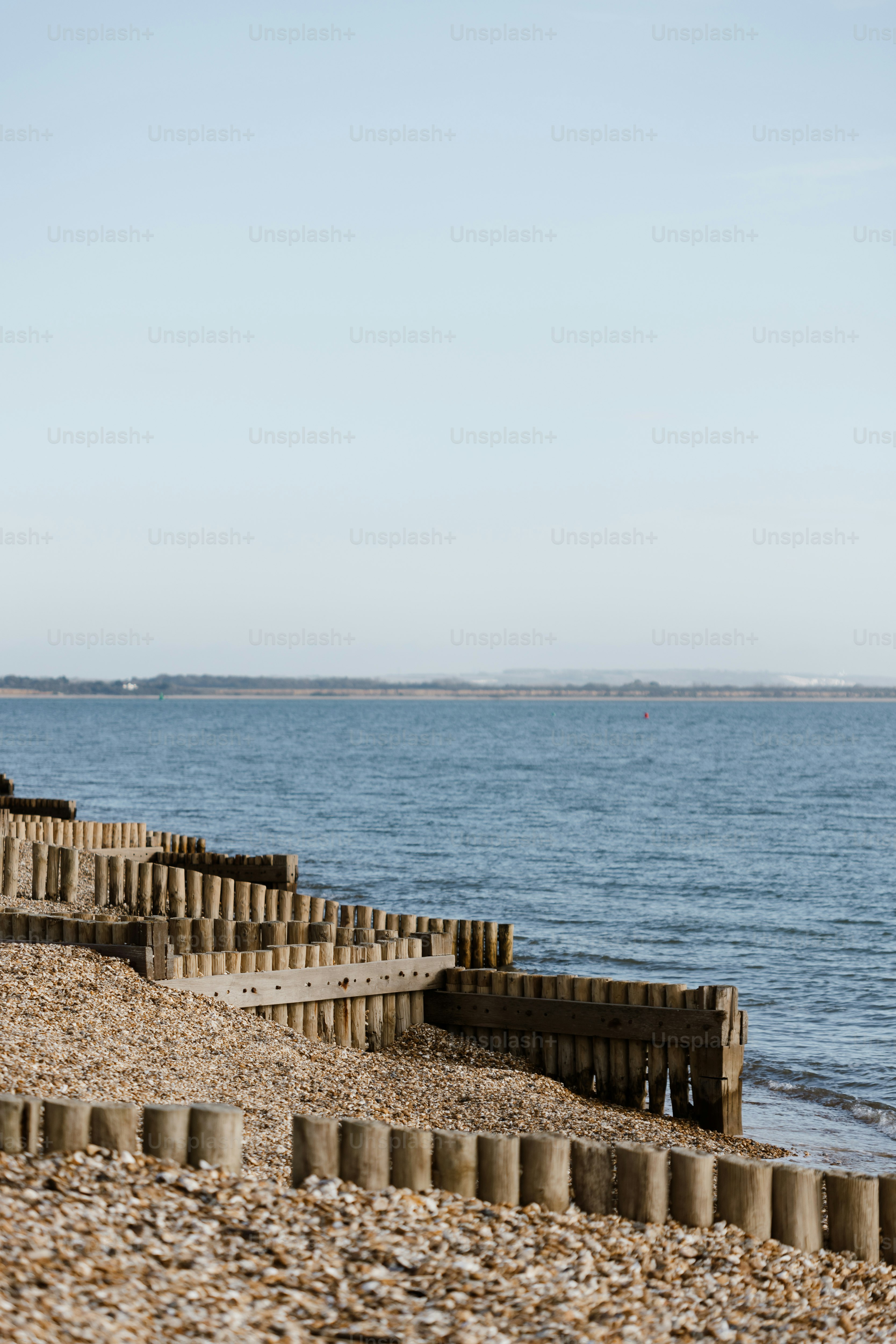 A person walking on a beach next to a body of water