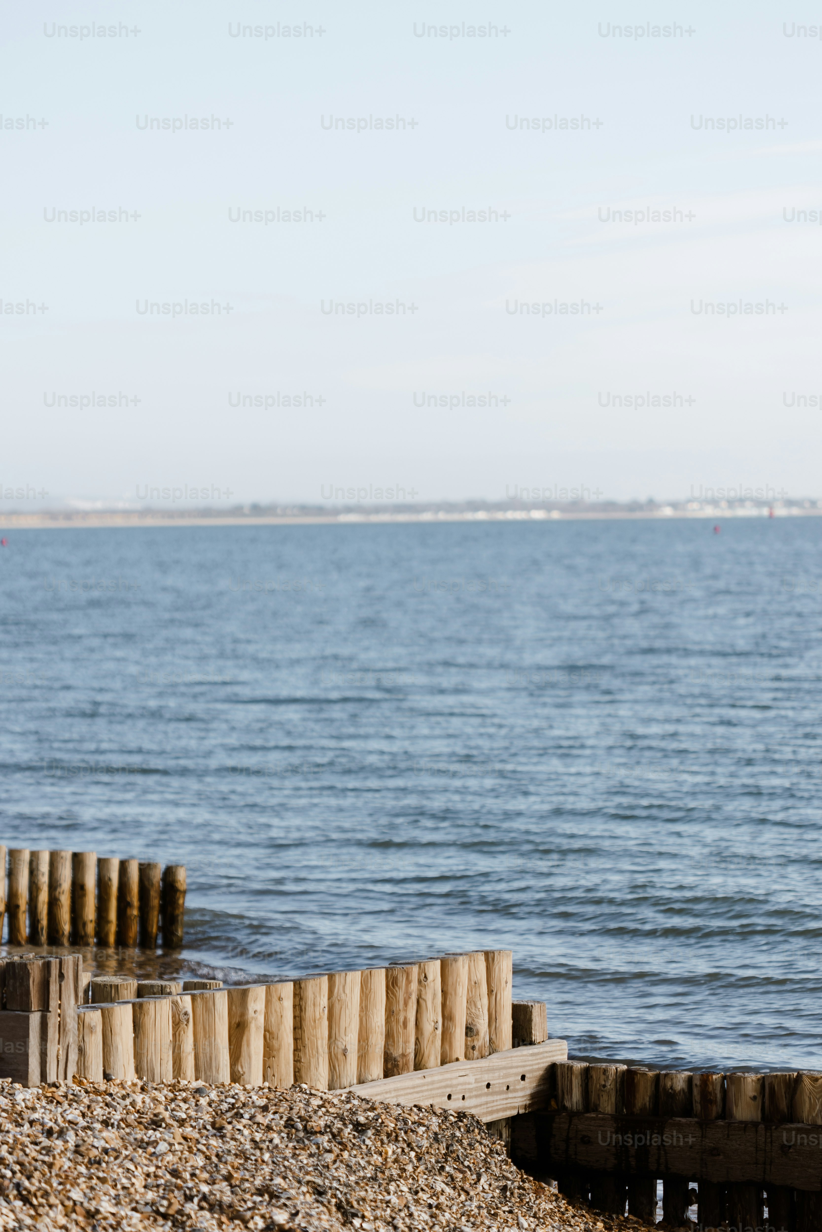 A wooden structure sitting on top of a beach next to the ocean