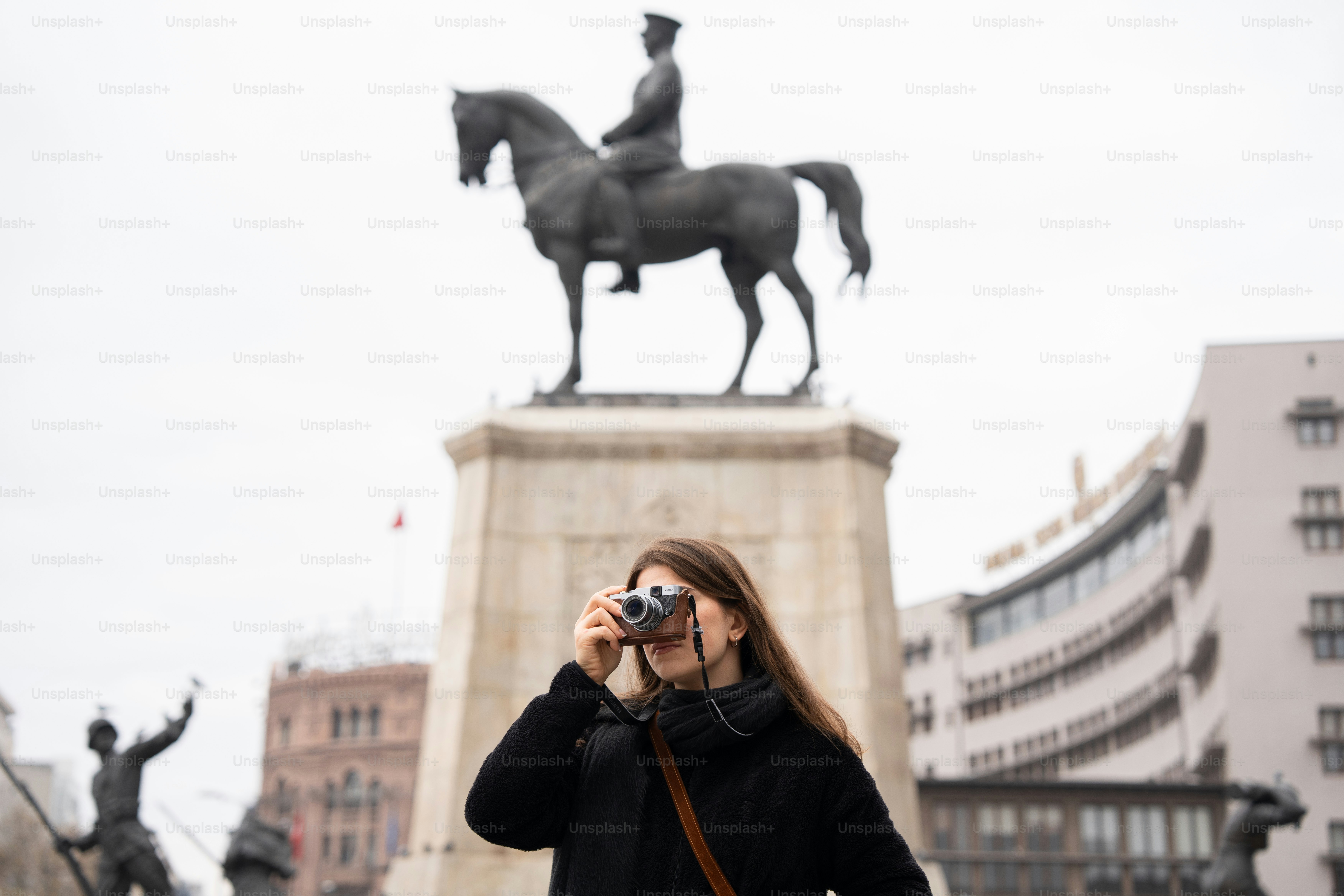 말과 기수의 동상을 촬영하는 여성