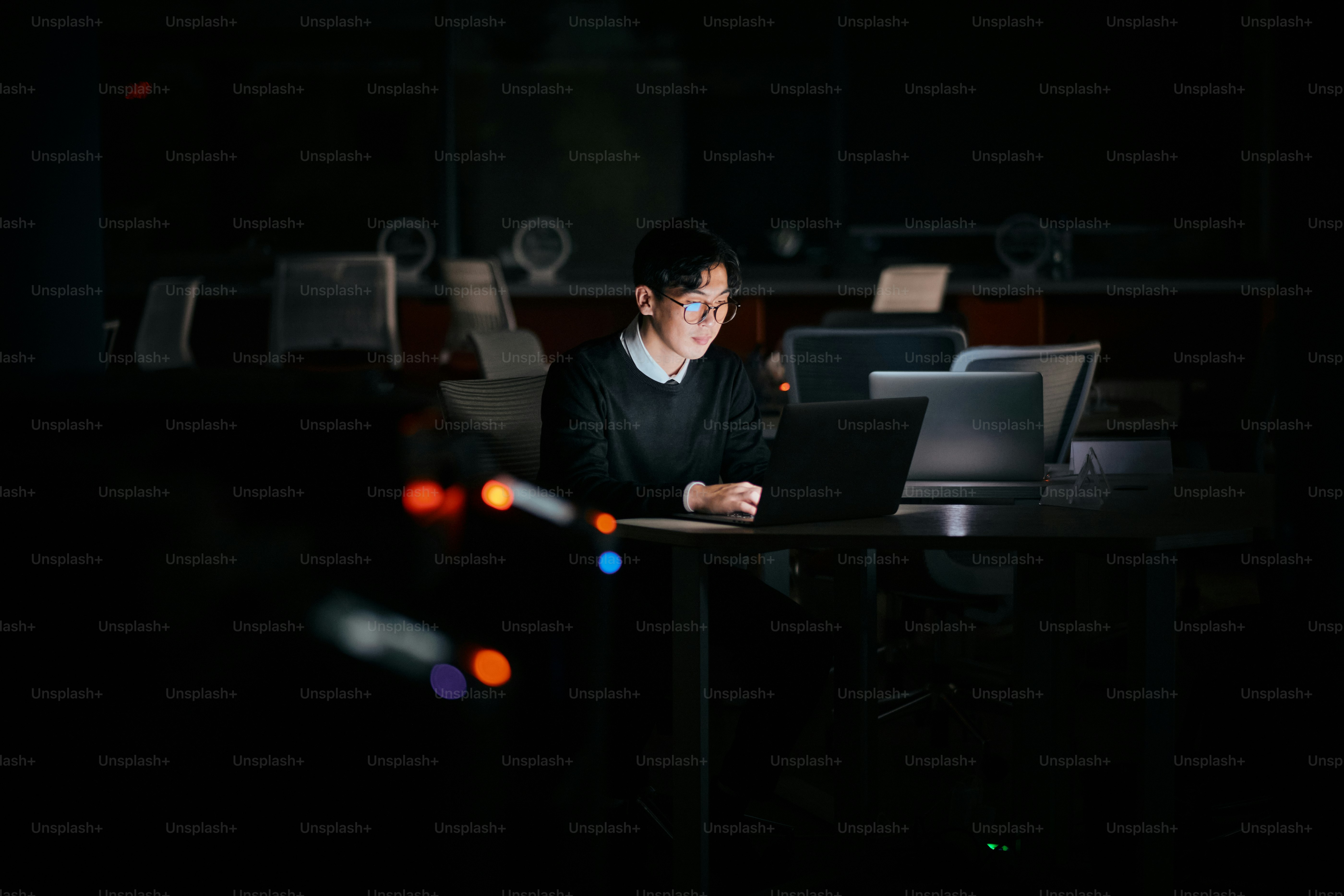 A man sitting at a desk using a laptop computer