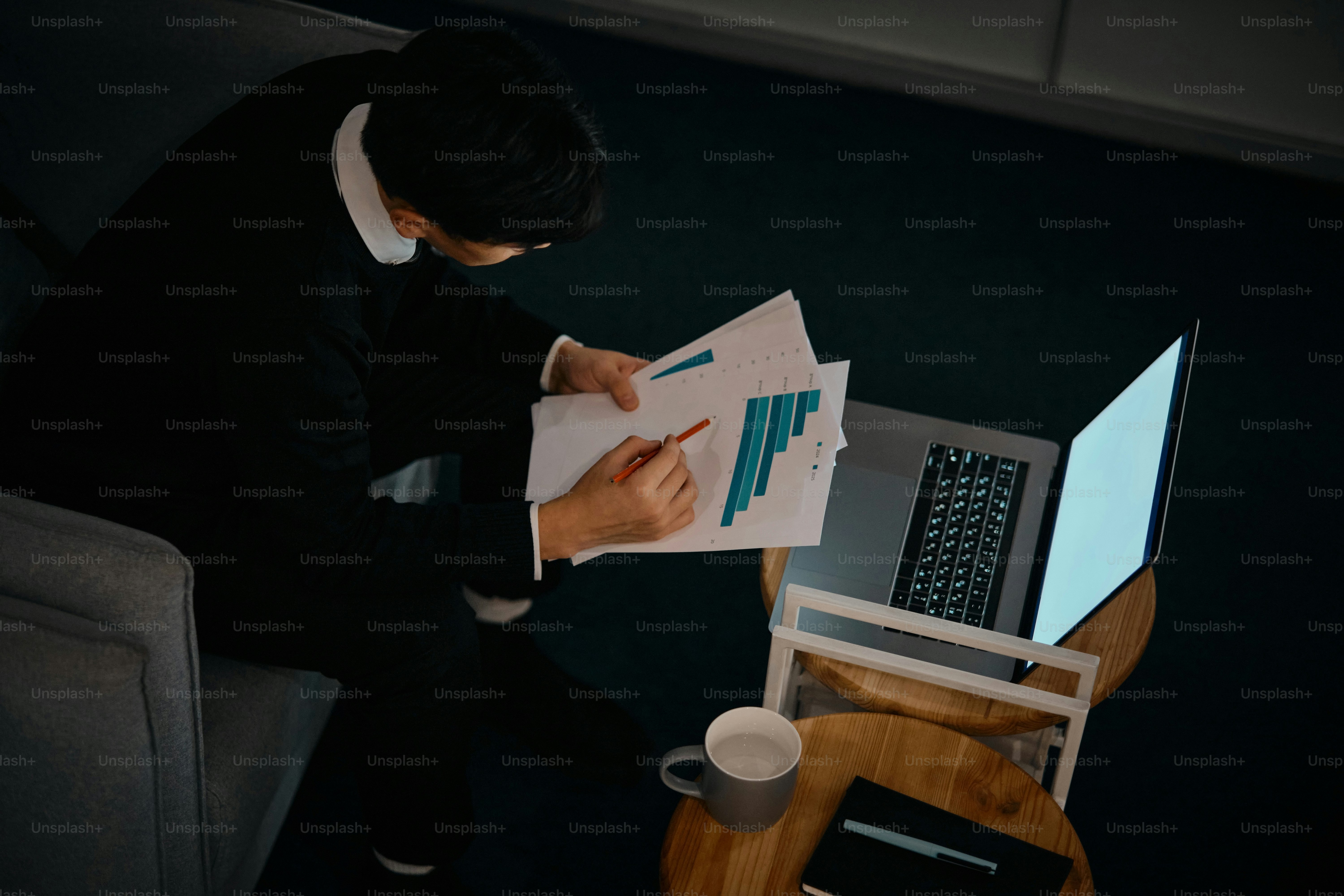 Ein Mann, der auf einem Stuhl sitzt und auf ein Blatt Papier schaut