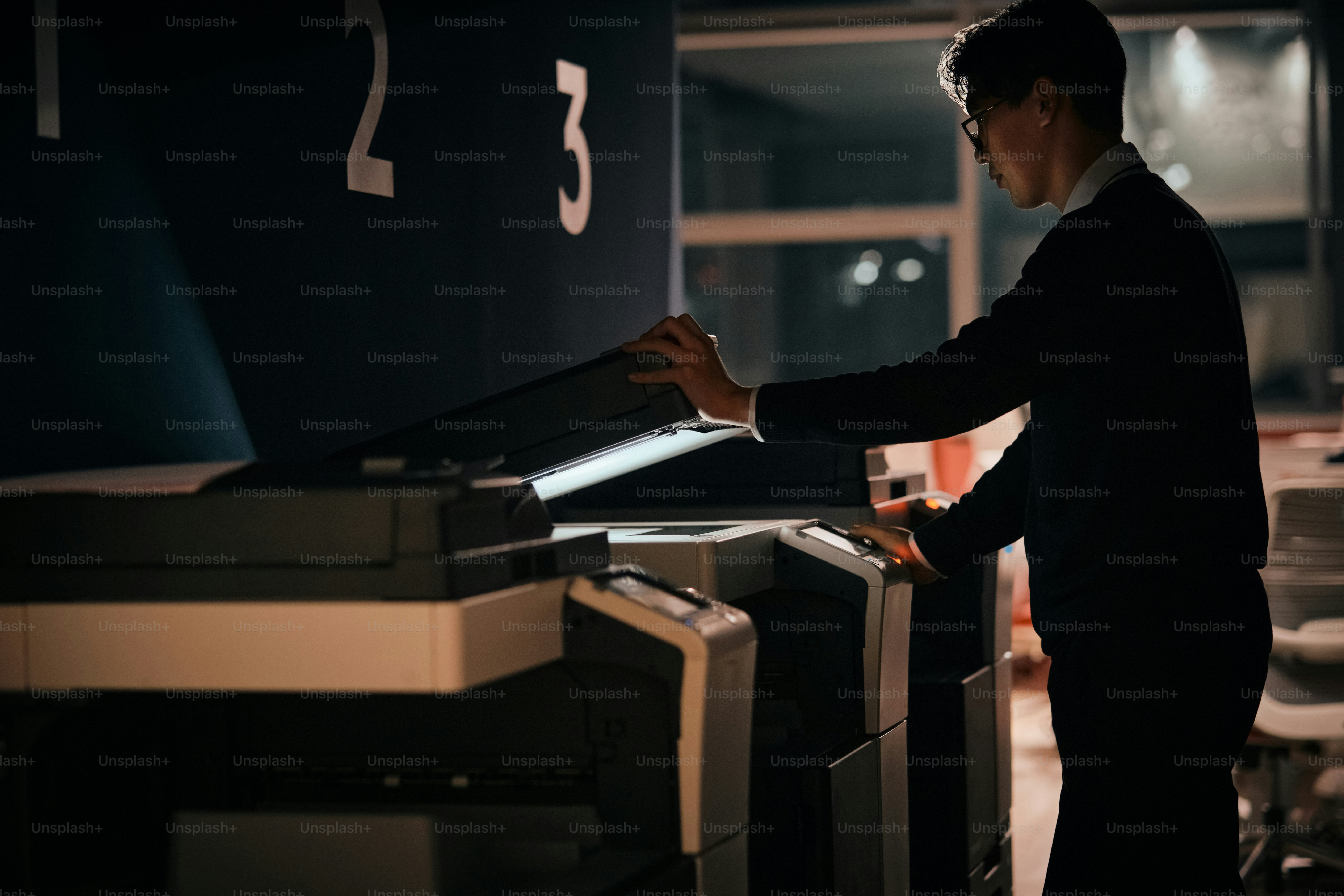 Ein Mann steht vor einer Reihe von Computermonitoren