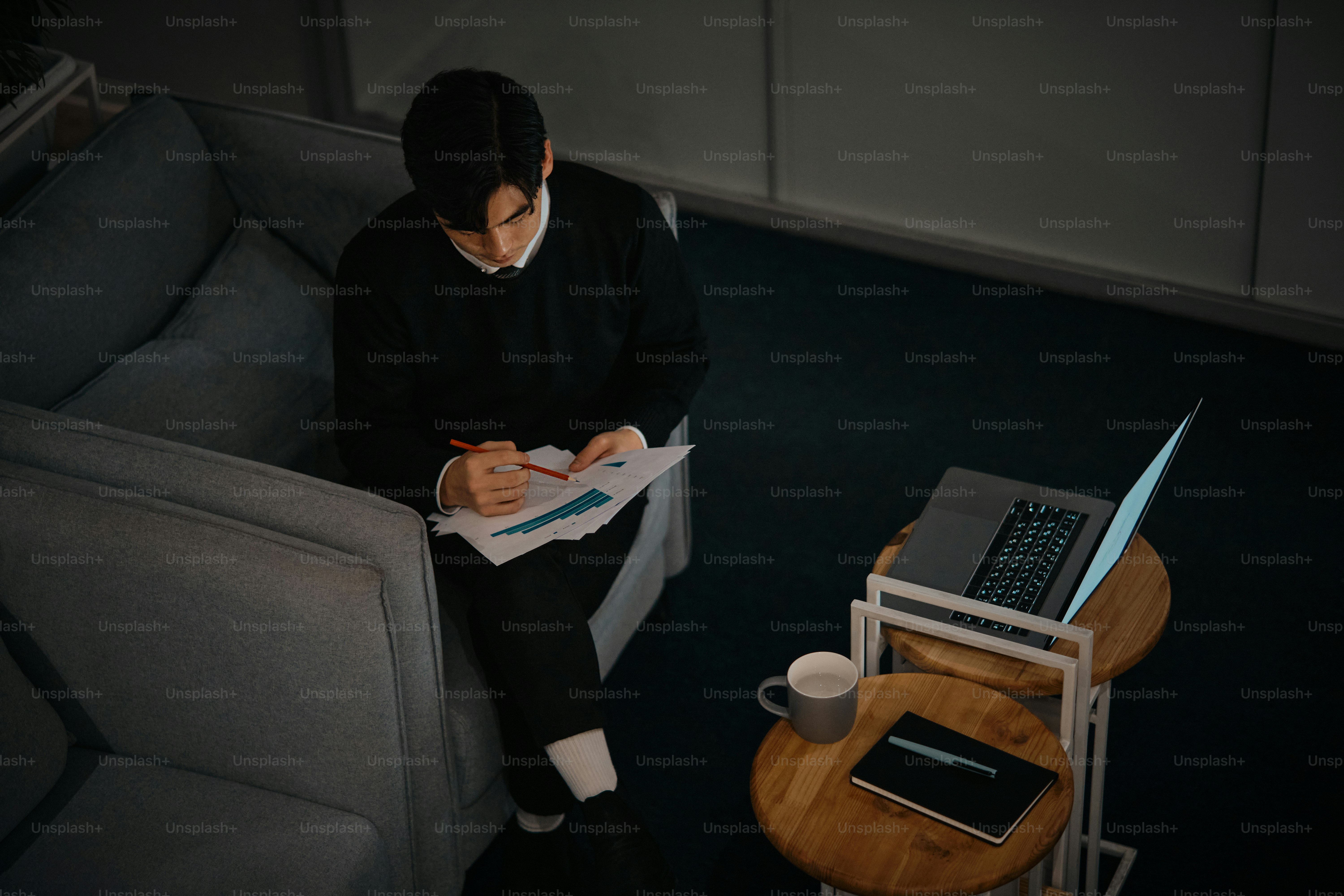 Eine Frau, die auf einer Couch neben einem Laptop sitzt