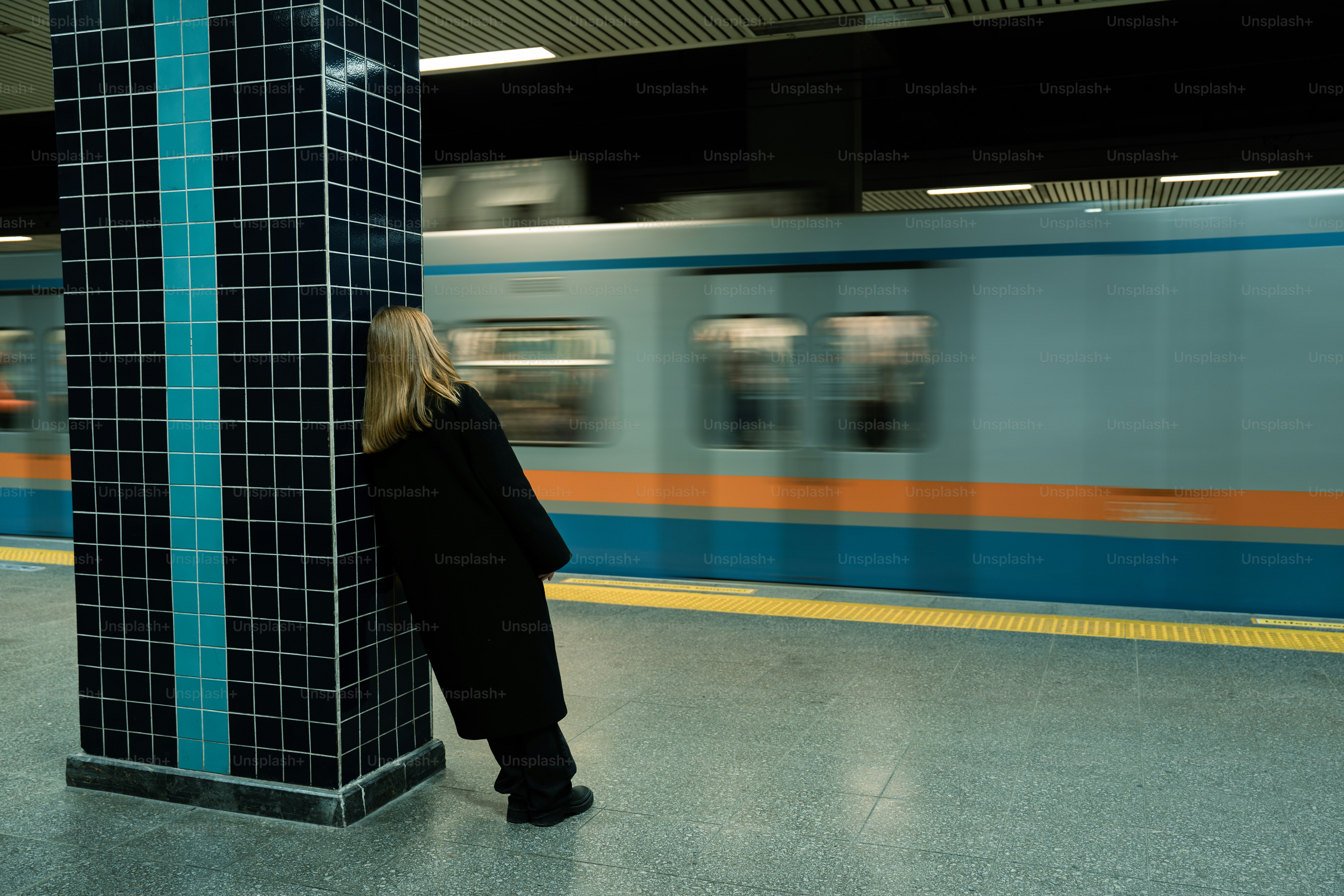 A woman is standing in a subway station