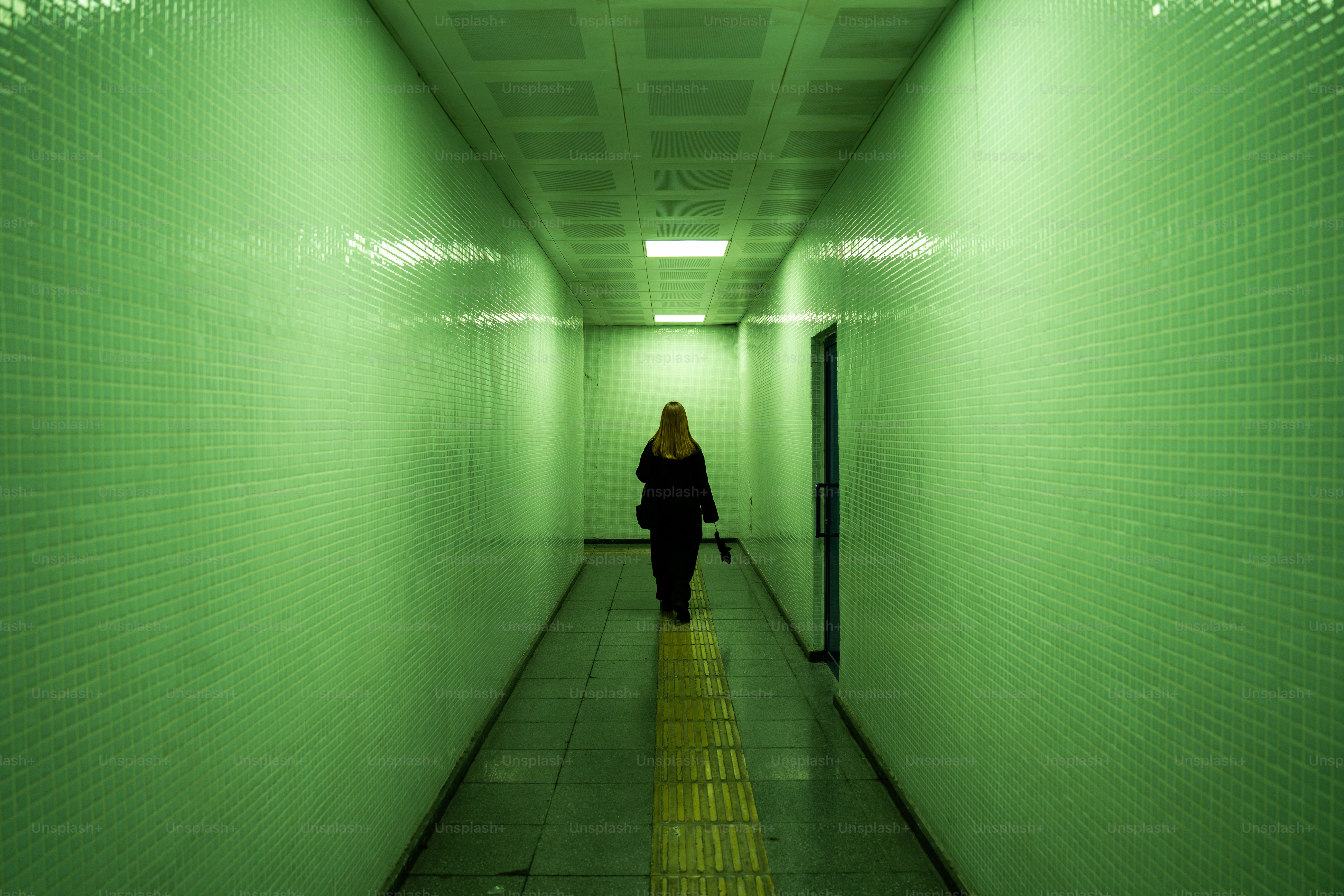A woman is walking down a long hallway