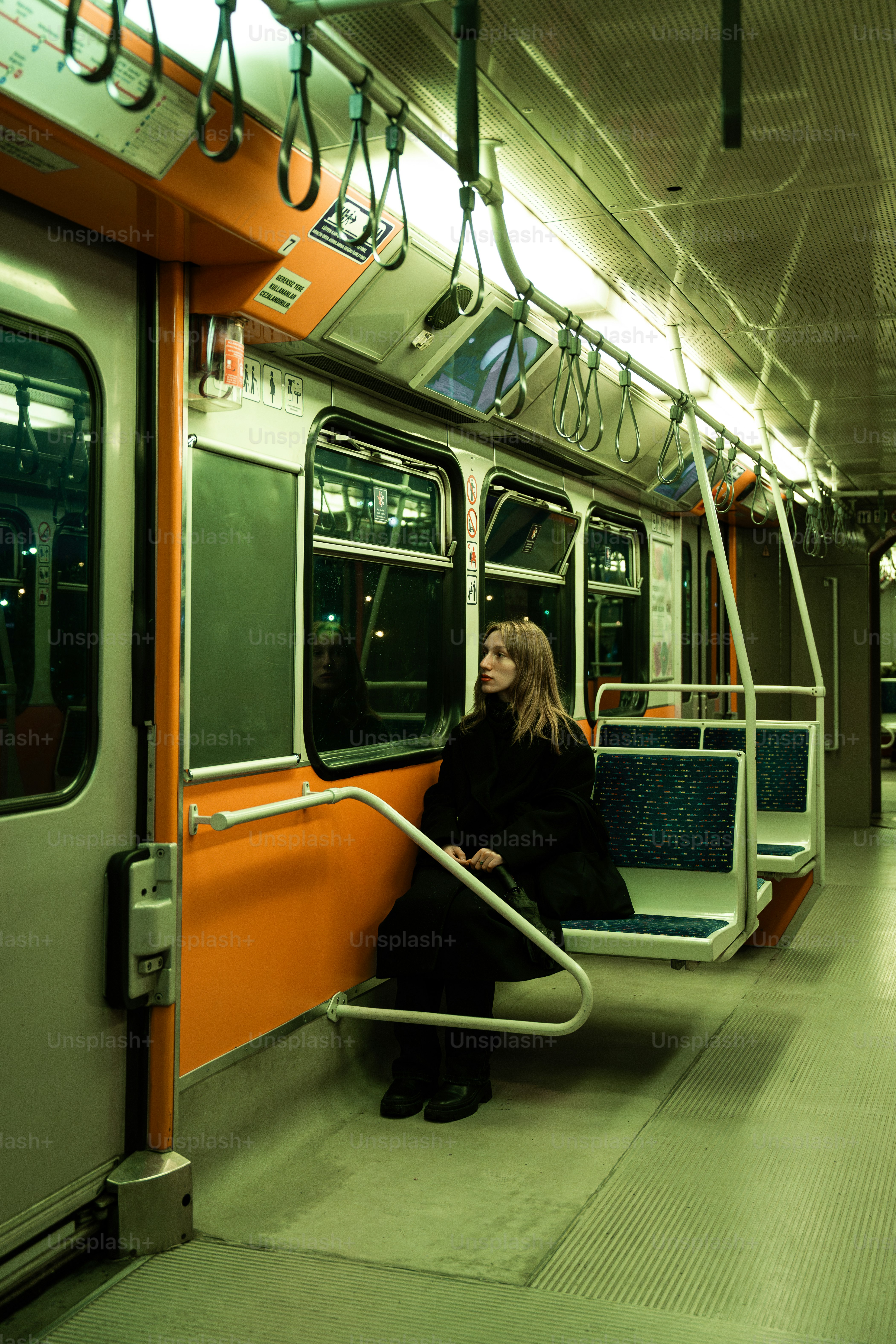 Uma mulher está sentada em um trem do metrô