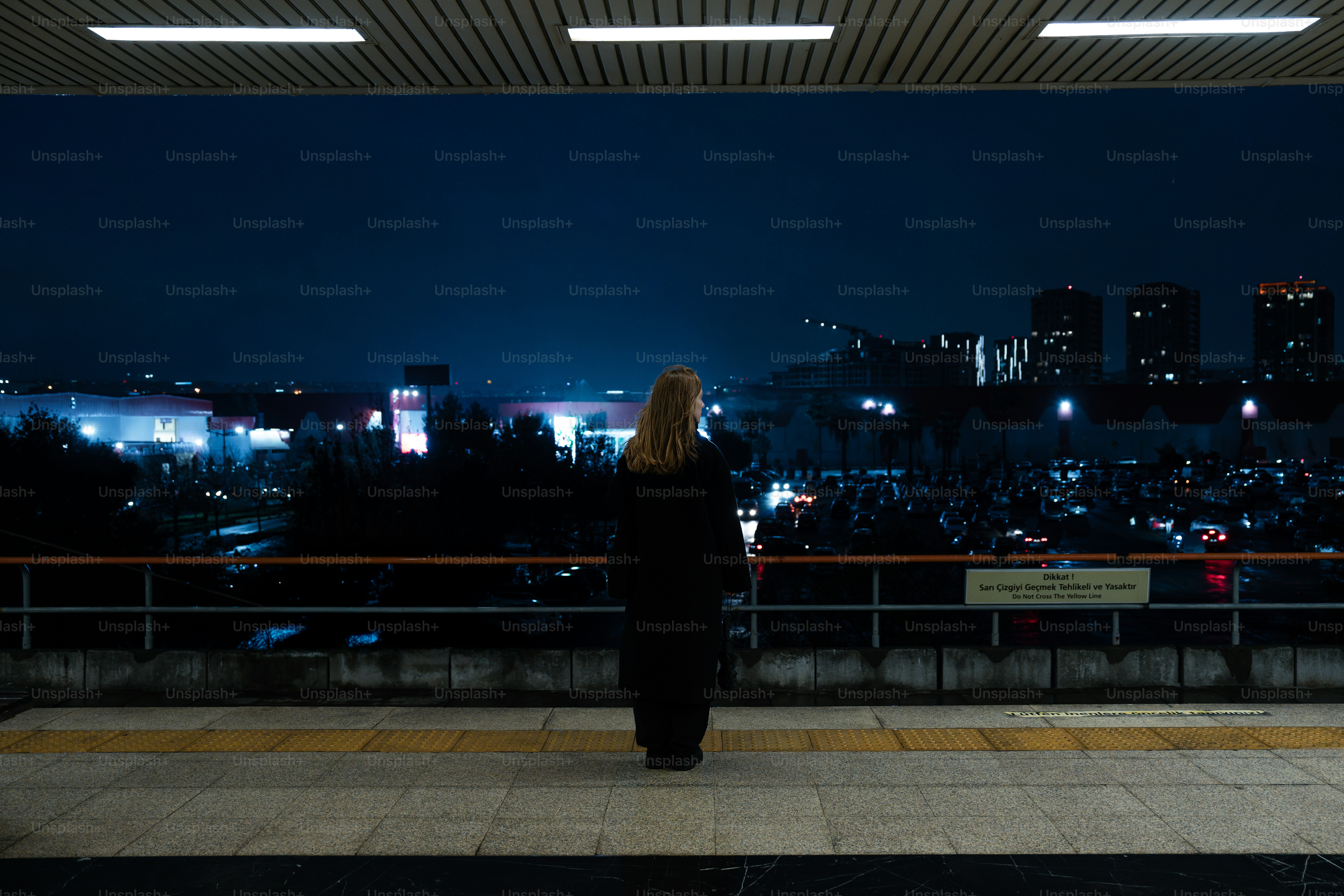 A woman standing in front of a window at night