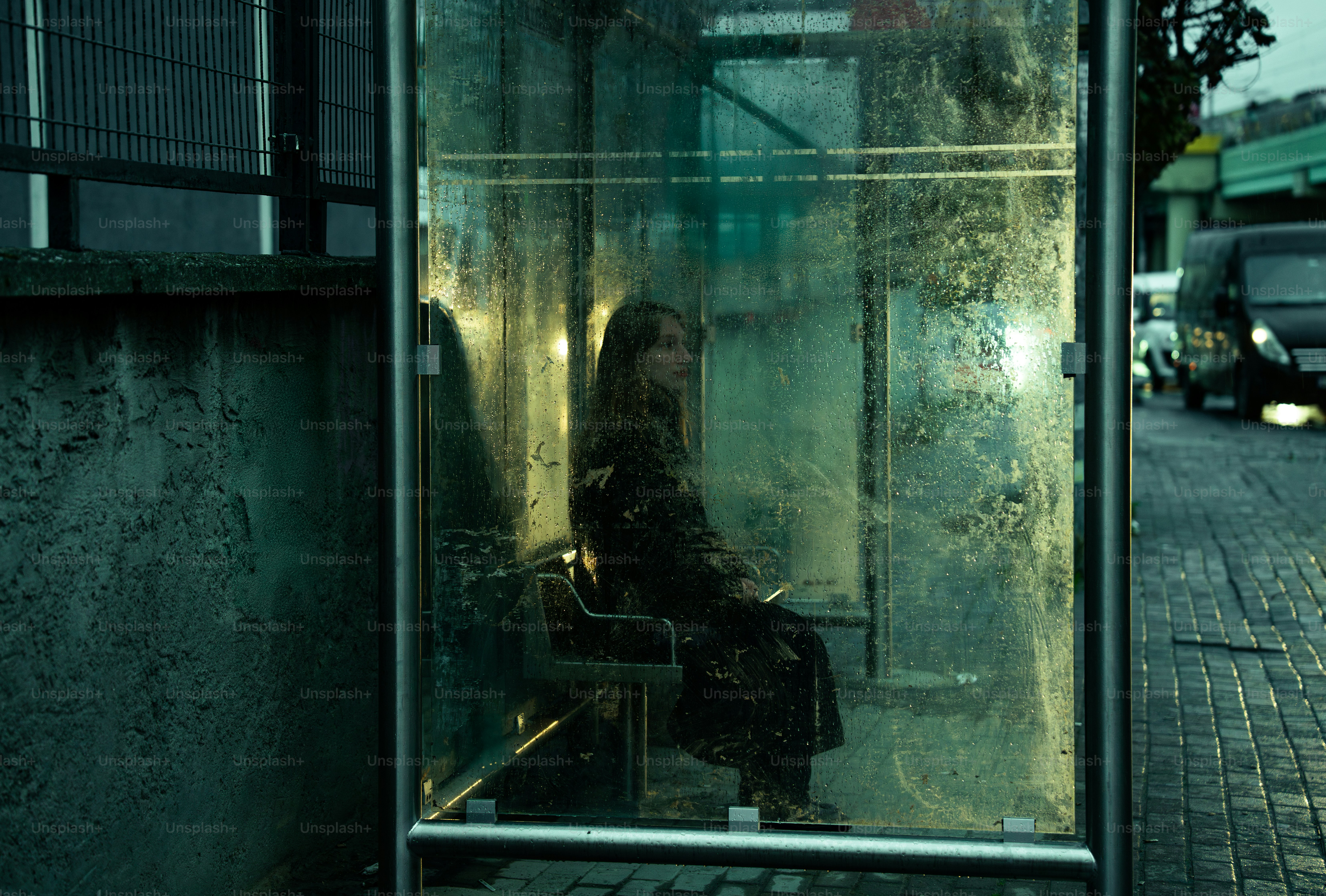 A woman is sitting in a bus stop