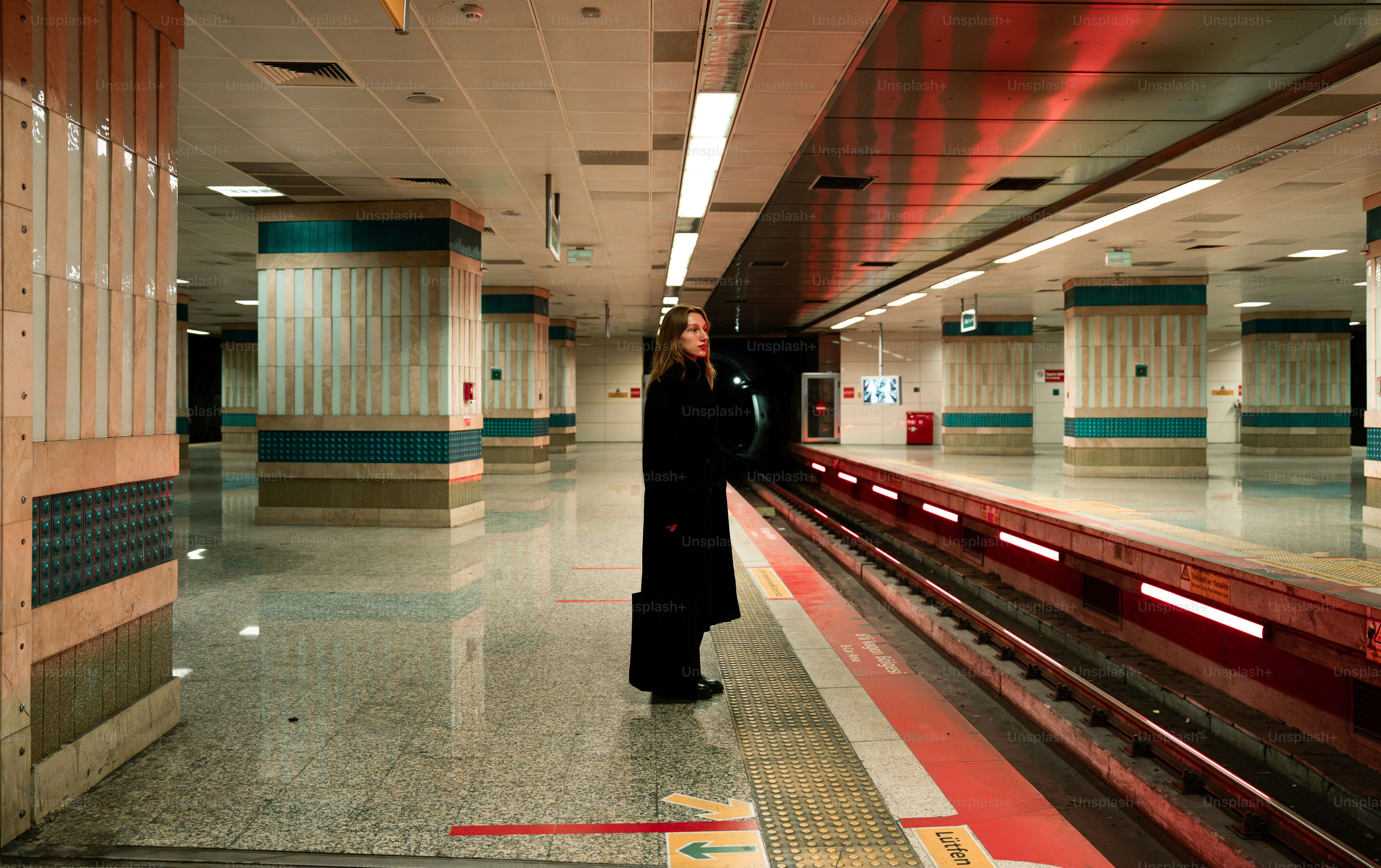 A man standing in a train station next to a train