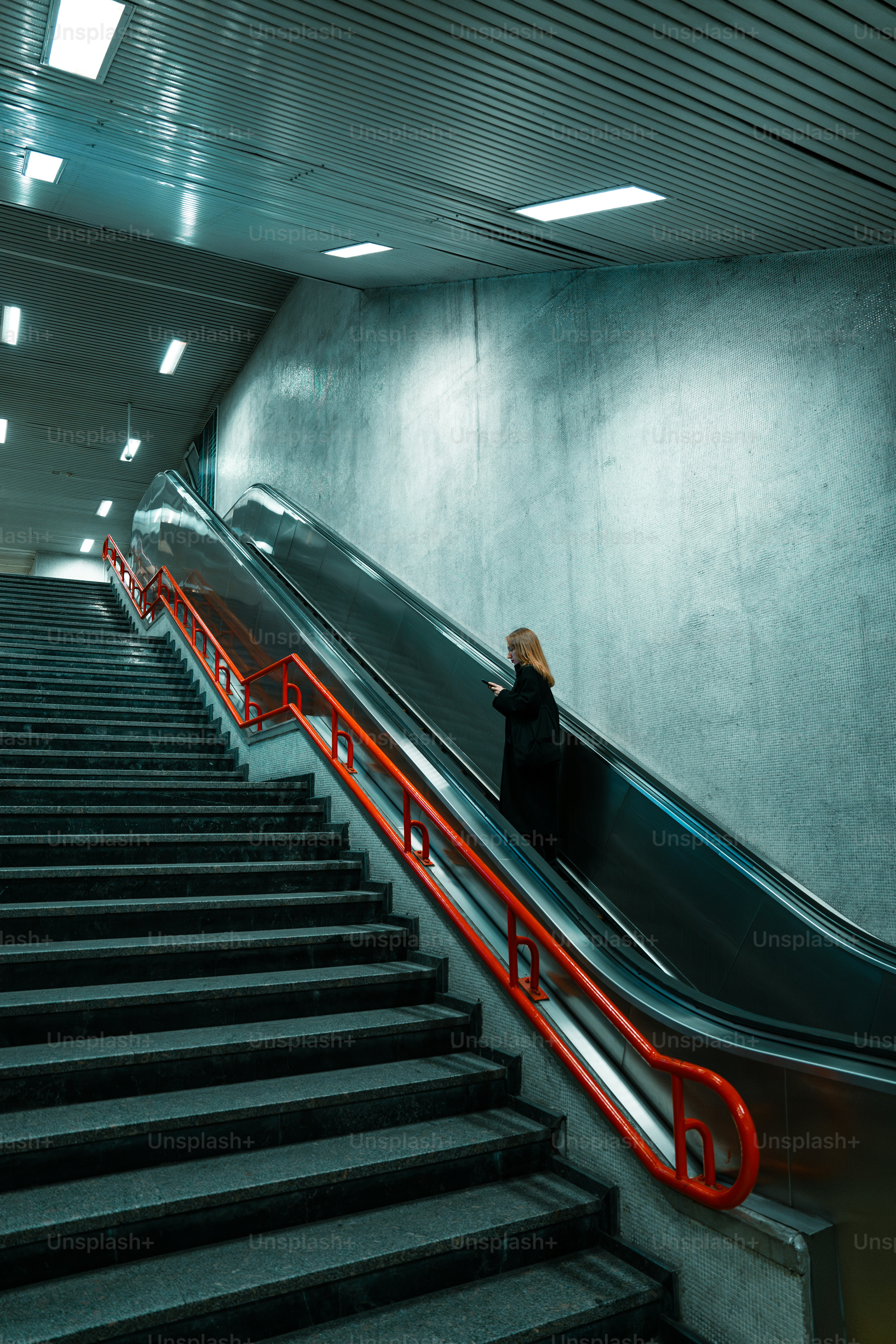 A person riding an escalator down a set of stairs