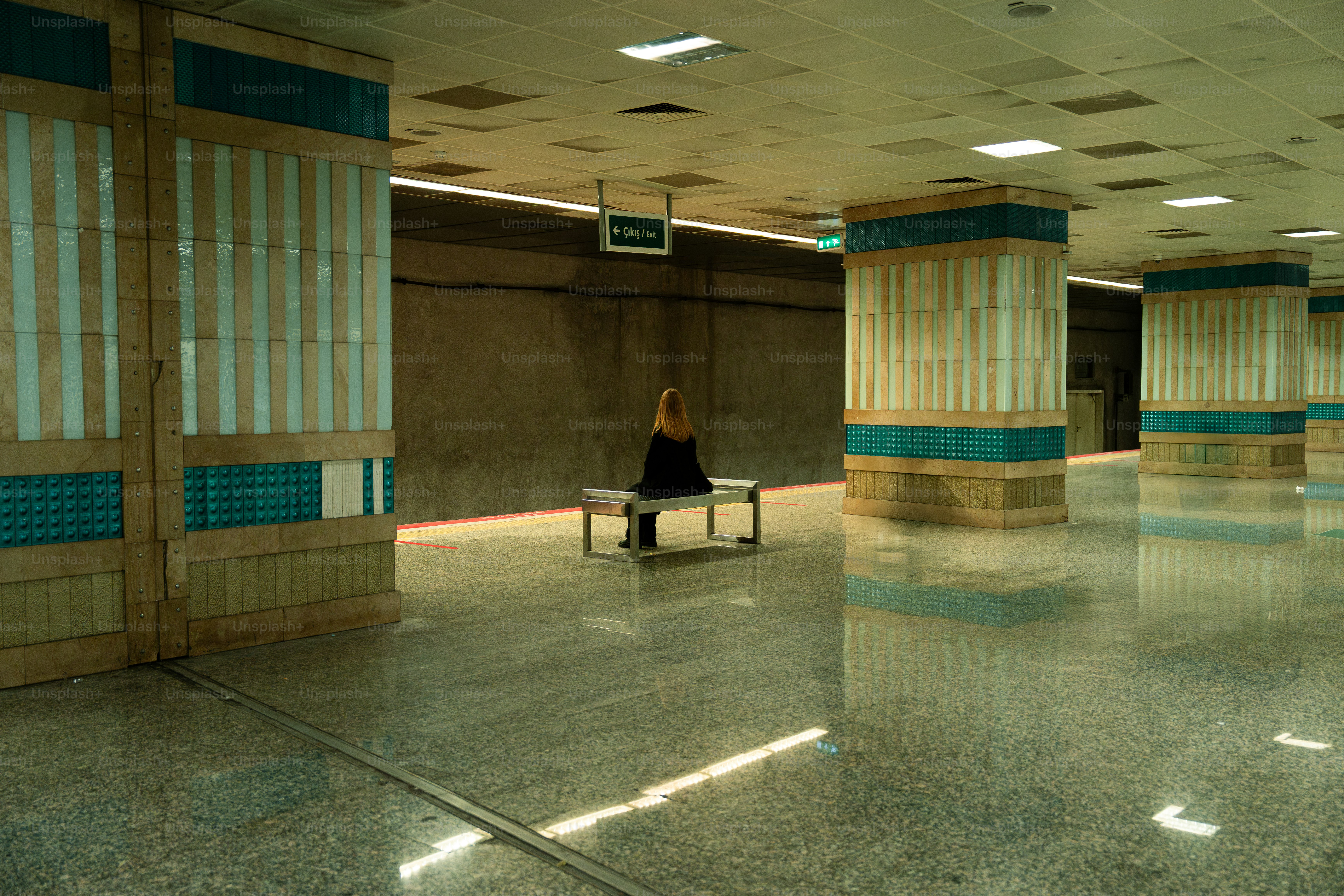 A woman sitting on a bench in an empty room