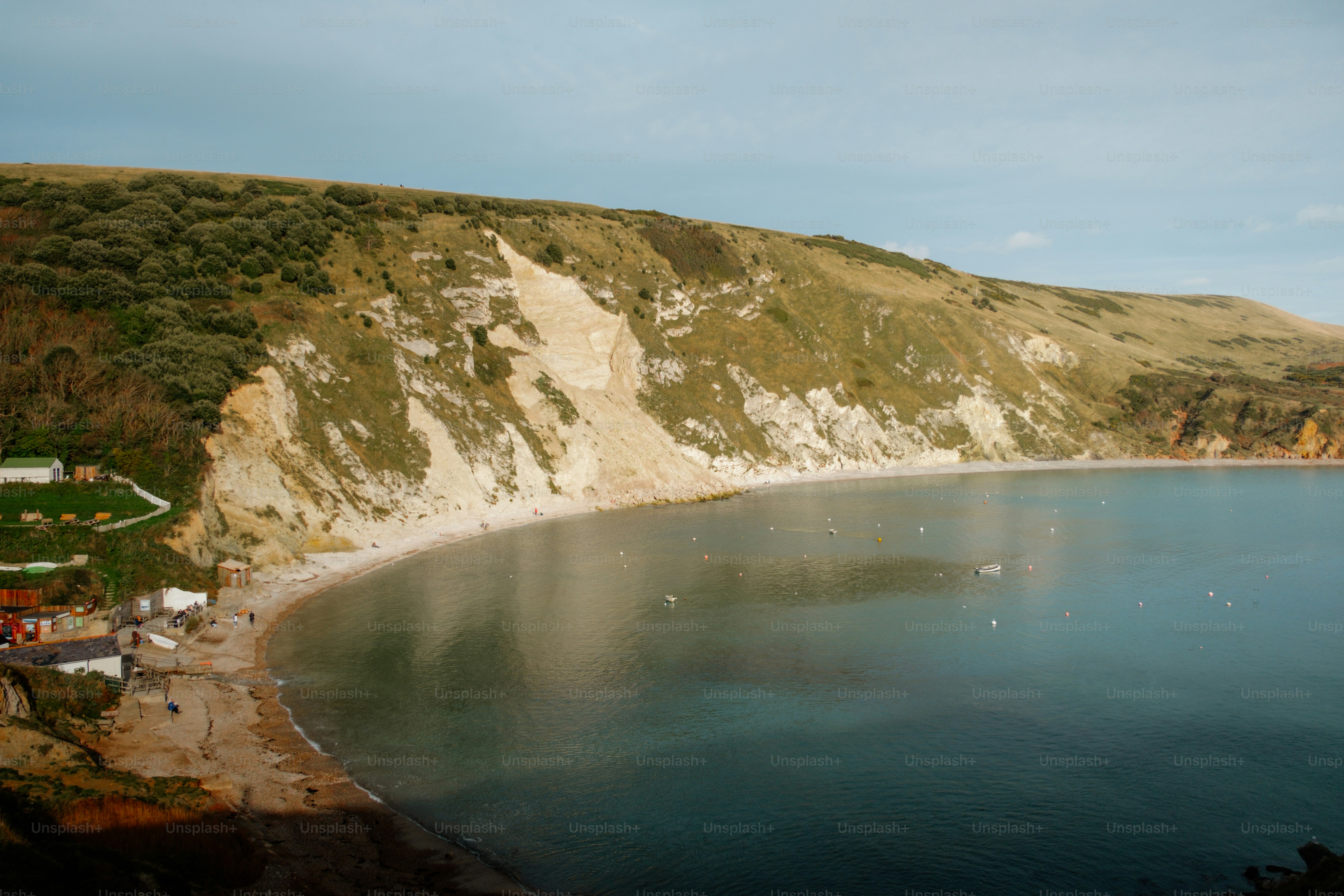 A large body of water surrounded by a lush green hillside